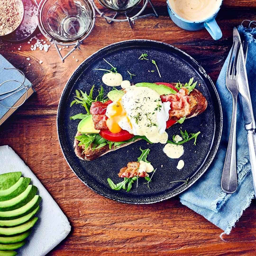 Ei mal anders: Genießen Sie mit unserem Eggs Benedict Rezept Avocado, Salat, Tomatenscheiben, Bacon, Sauce Hollandaise und pochierte Eier auf gerösteten Brotscheiben.