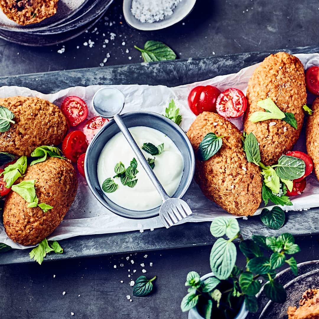 Kibbeh kommen aus dem Nahen Osten und sind und sind kleine selbst hergestellte Bällchen oder Klöße aus Bulgur und Hackfleisch. Dazu servieren wir einen selbstgemachten Joghurt-Minz-Dip!