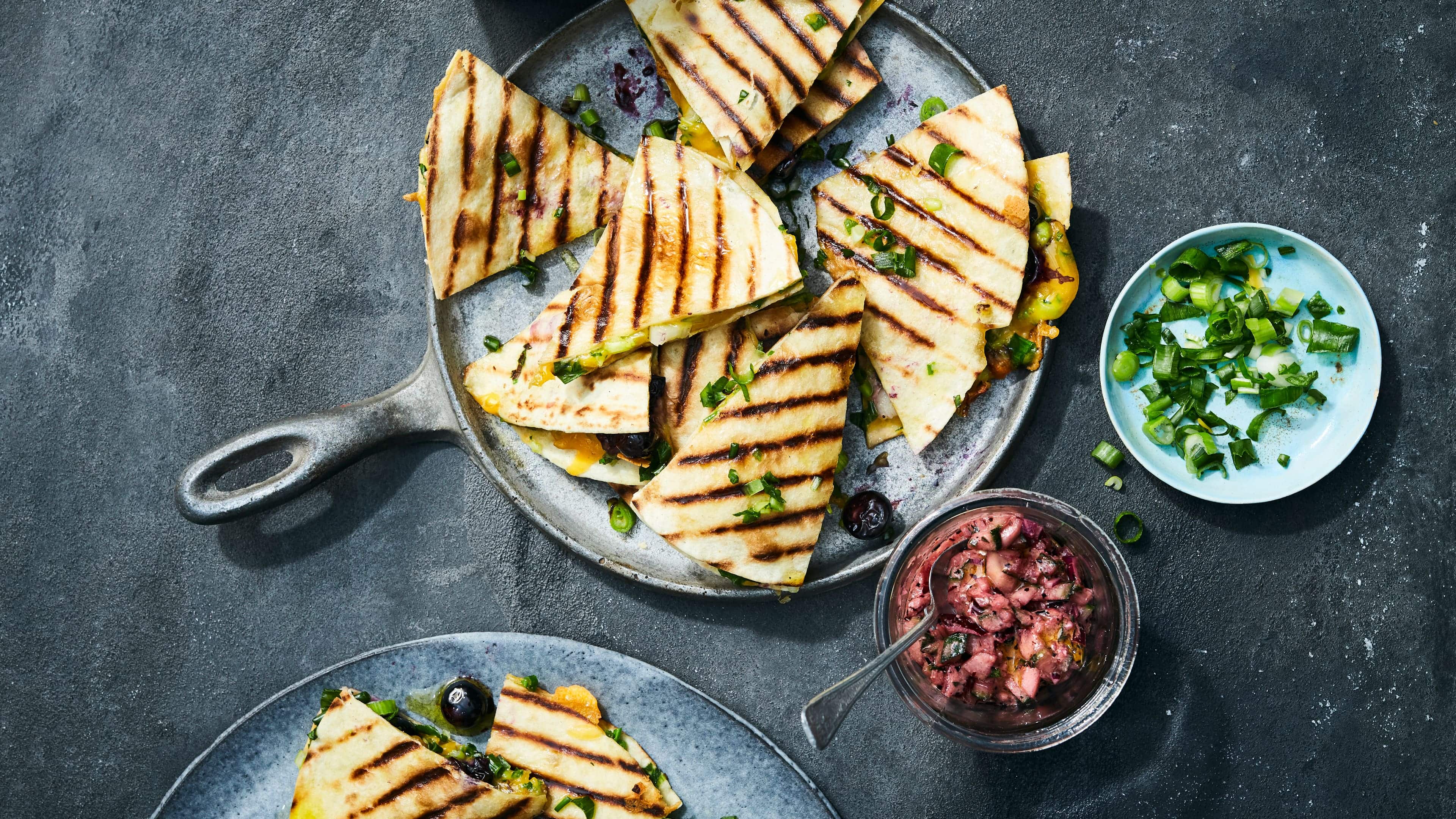 Quesadillas mit Heidelbeeren und Gurkensalsa Die kleinen Weizentortillas kombinieren wir mal ganz außergewöhnlich: Probieren Sie unser Rezept für Quesadillas mit Heidelbeeren, Gurkensalsa und viel würzigem Cheddar.