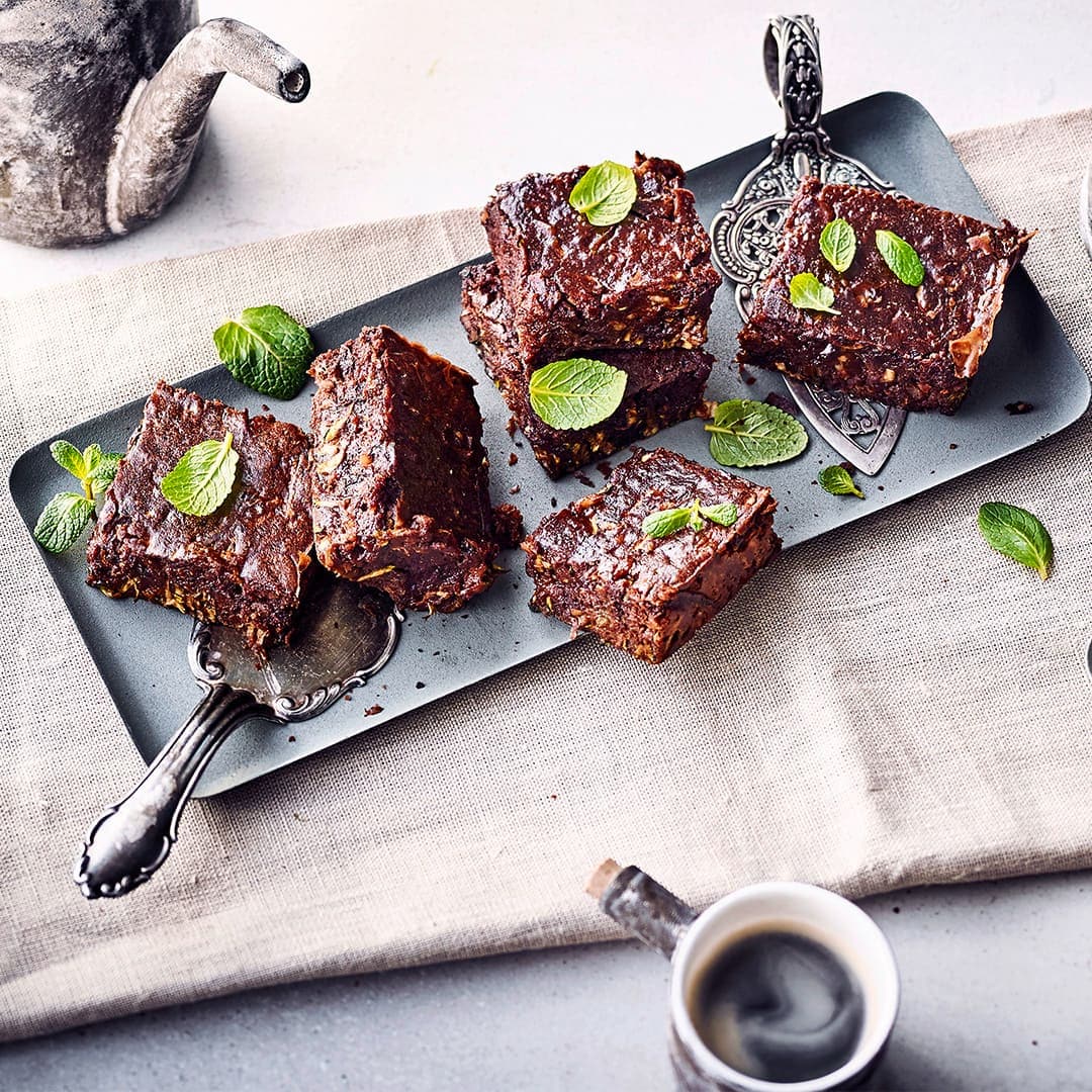 Diese Kombi müssen Sie probieren! Saftige Brownies aus Schokolade und Zucchini können je nach Belieben sogar vegan zubereitet werden – einfach die Vollmilch durch Mandelmilch ersetzen.