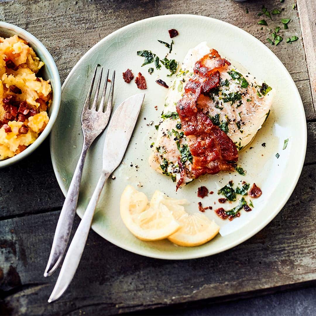 Köstlicher Kabeljau mit Speck in Folie gewickelt und gegrillt, dazu servieren wir holländischen Stamppot aus Kartoffeln, Speck und Möhren.