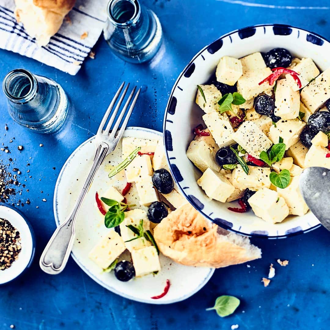 Griechischer Schafskäse schmeckt nach Urlaub und einer griechischen Taverne - ganz einfach selbermachen: Feta eingelegt mit Knoblauch, Kräutern, Peperoni und Oliven.