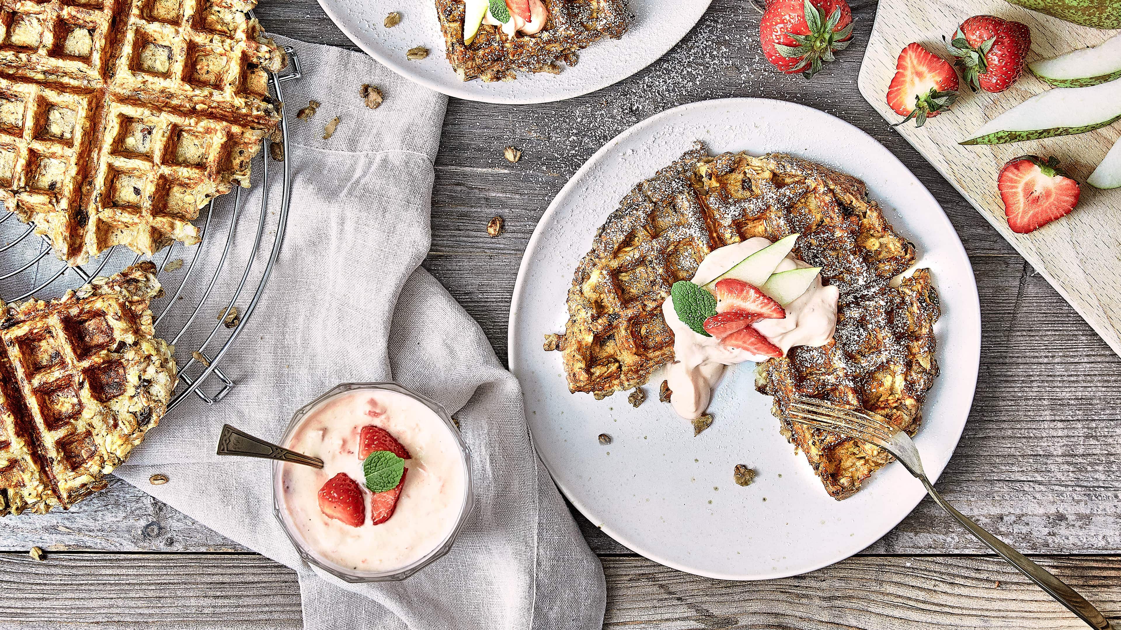 Birnenwaffeln Fruchtig und süß: Probieren Sie unsere kernigen Birnenwaffeln mit getrockneten Pflaumen und Haferflocken an einer Vanillecreme mit Zimt und frischen Erdbeeren!