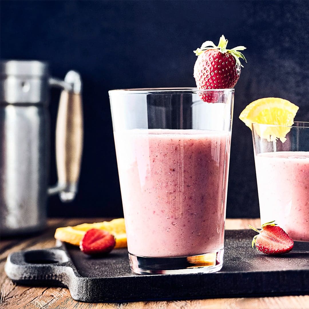 Fruchtiger Sommerdrink: Probieren Sie unseren Orange-Erdbeer-Shake mit Ahornsirup, Buttermilch und Vierkornflocken - erfrischend und nahrhaft zugleich!