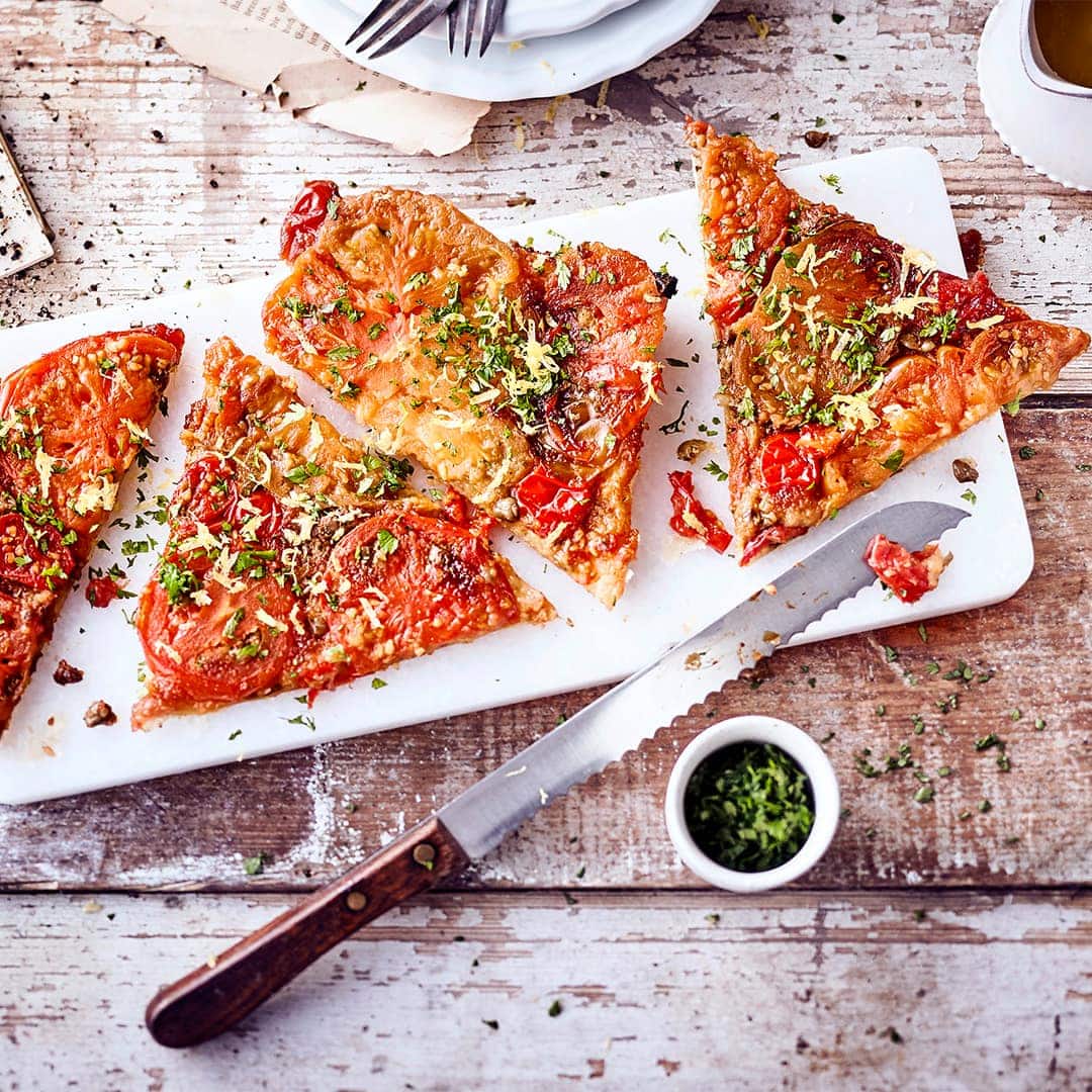 Verzaubern Sie Ihre Liebsten mit diesem pikanten Gemüsegericht aus dem Ofen: Probieren Sie unsere Kirschtomaten-Tarte-Tatin mit frischen Kräutern und einem selbstgemachten Ziegenfrischkäse-Dip.