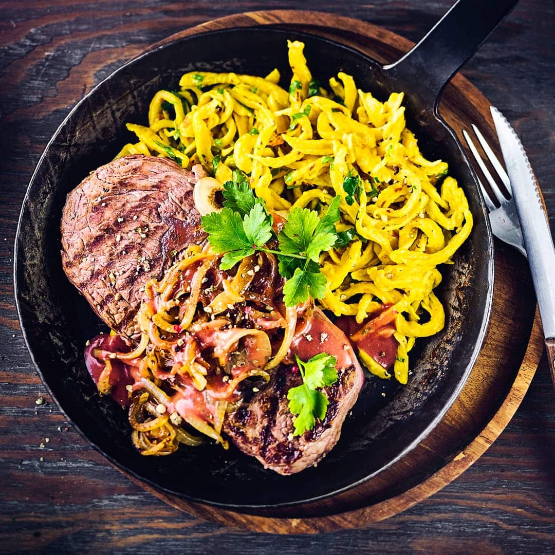 Probieren Sie unser laktosefreies Rezept für Zwiebelrostbraten: Mit saftigem Rumpsteak, feinwürzigem Sauerkraut und raffinierten Kürbis-Kräuterspätzle!