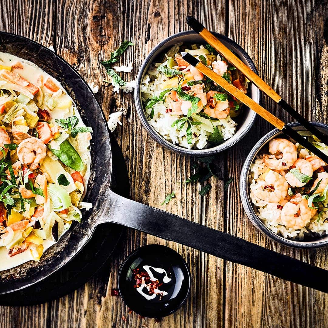 Ganz fix und ganz lecker: Kochen Sie eine asiatische Gemüsepfanne mit Garnelen, Kokosmilch, Sesamöl und Basmatireis zu. Völlig glutenfrei!