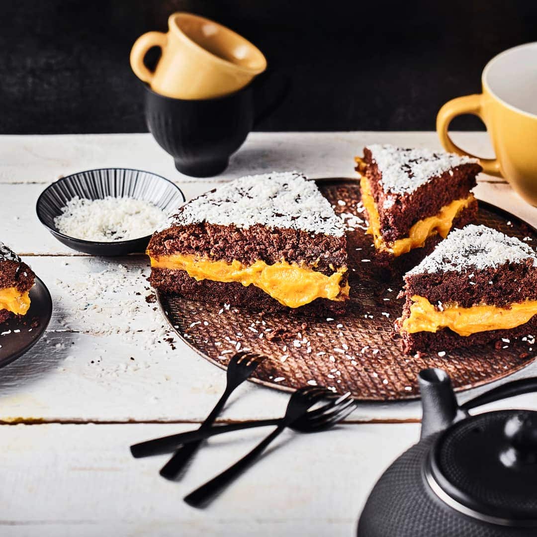 Cremiges Kürbispürree zwischen zwei schokoladigen Kuchenböden getoppt mit köstlichen Kokosraspeln - unser herbstlicher Kürbis-Schoko-Kuchen besticht mit jeder Menge Aromen.
