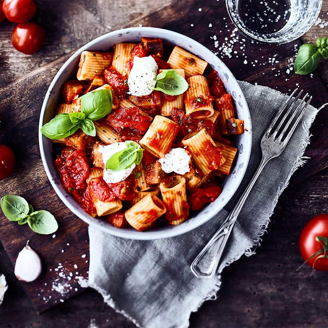 Ein traditionelles, leicht scharfes Gericht der sizilianischen Küche: Pasta alle Norma mit Auberginen, geschälten Tomaten, Nudeln und einem Klecks Ricotta.