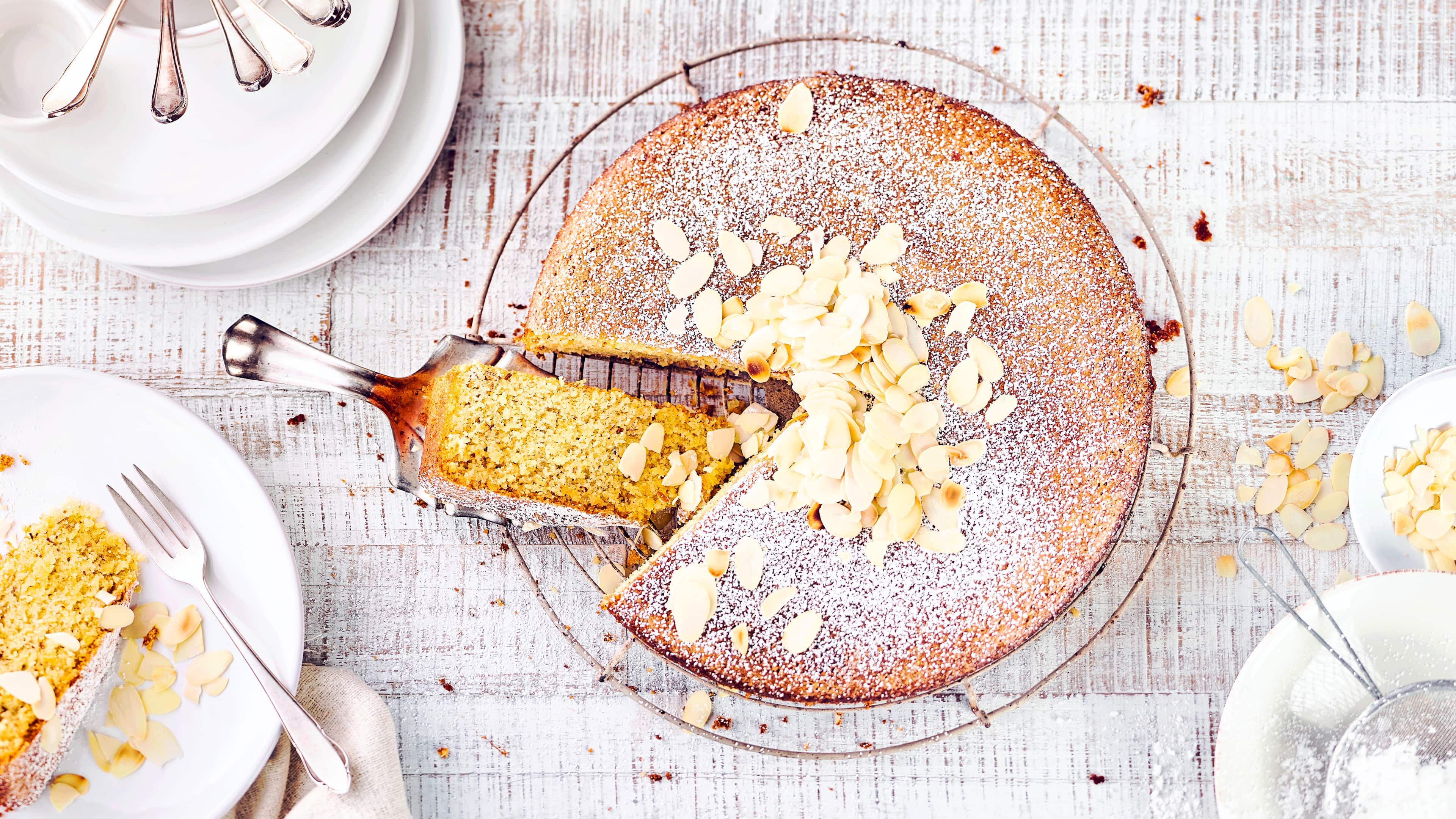 Spanischer Mandelkuchen Spanischer Mandelkuchen ist rund, mit Puderzucker bedeckt, ist innen goldgelb und schmeckt einfach köstlich nach Mandeln. Der heiße Kuchen wird mit Mandellikör beträufelt und erhält dadurch einen ganz besonderen Geschmack.