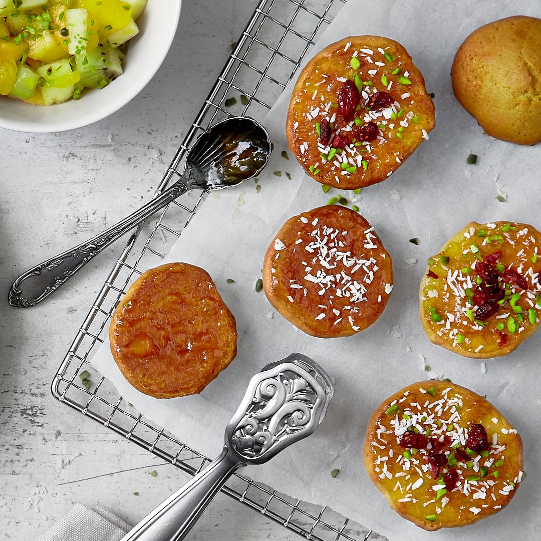 Backen Sie nach unserem Rezept leckere Mini-Amerikaner mit einem Topping aus Kokosflocken, gehackten Pistazien und fruchtigen Cranberrys.