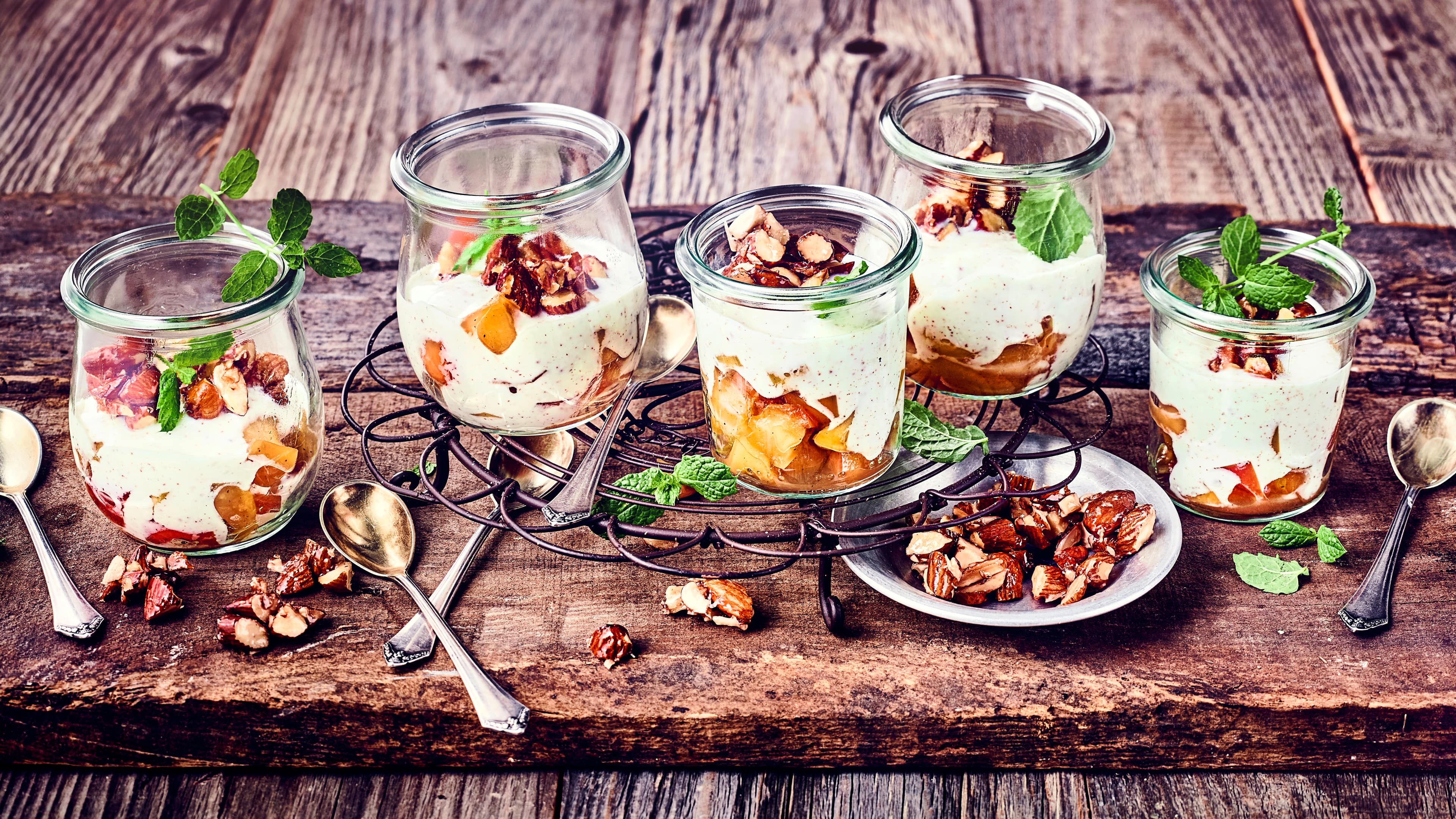 Apfelmus mit Zimtcreme und Karamellmandeln Selbstgemachtes Apfelmus mit Zimtcreme und karamellisierten Mandeln ist auf Gläsern verteilt nicht nur ein geschmackliches Erlebnis.