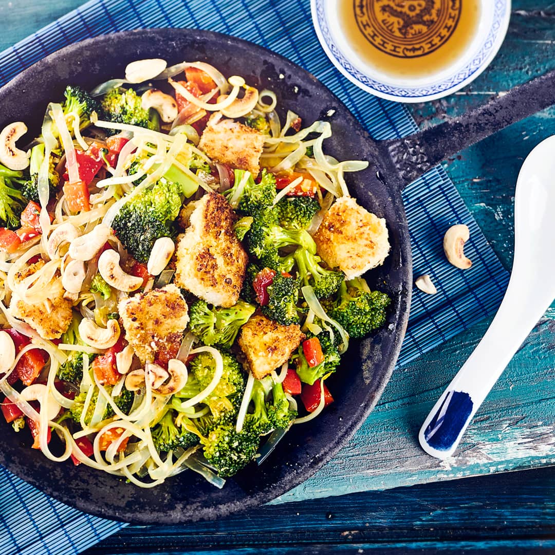 Unser Rezept für eine asiatische Nudelpfanne ist gluten- und laktosefrei: Mit Broccoli, Kabeljau-Filet und Cashewkernen – probieren Sie es gleich mal aus!