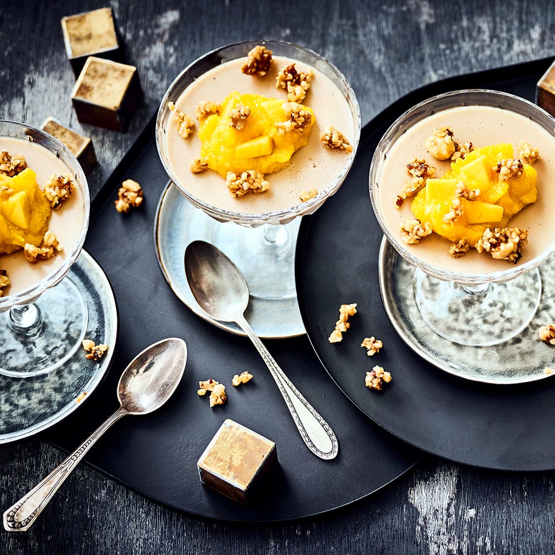 Genießen Sie unser Rezept für Baileys Panna cotta -  Ein cremig zartes Dessert, mit Mango-Püree und karamellisierten Haselnüssen garniert.