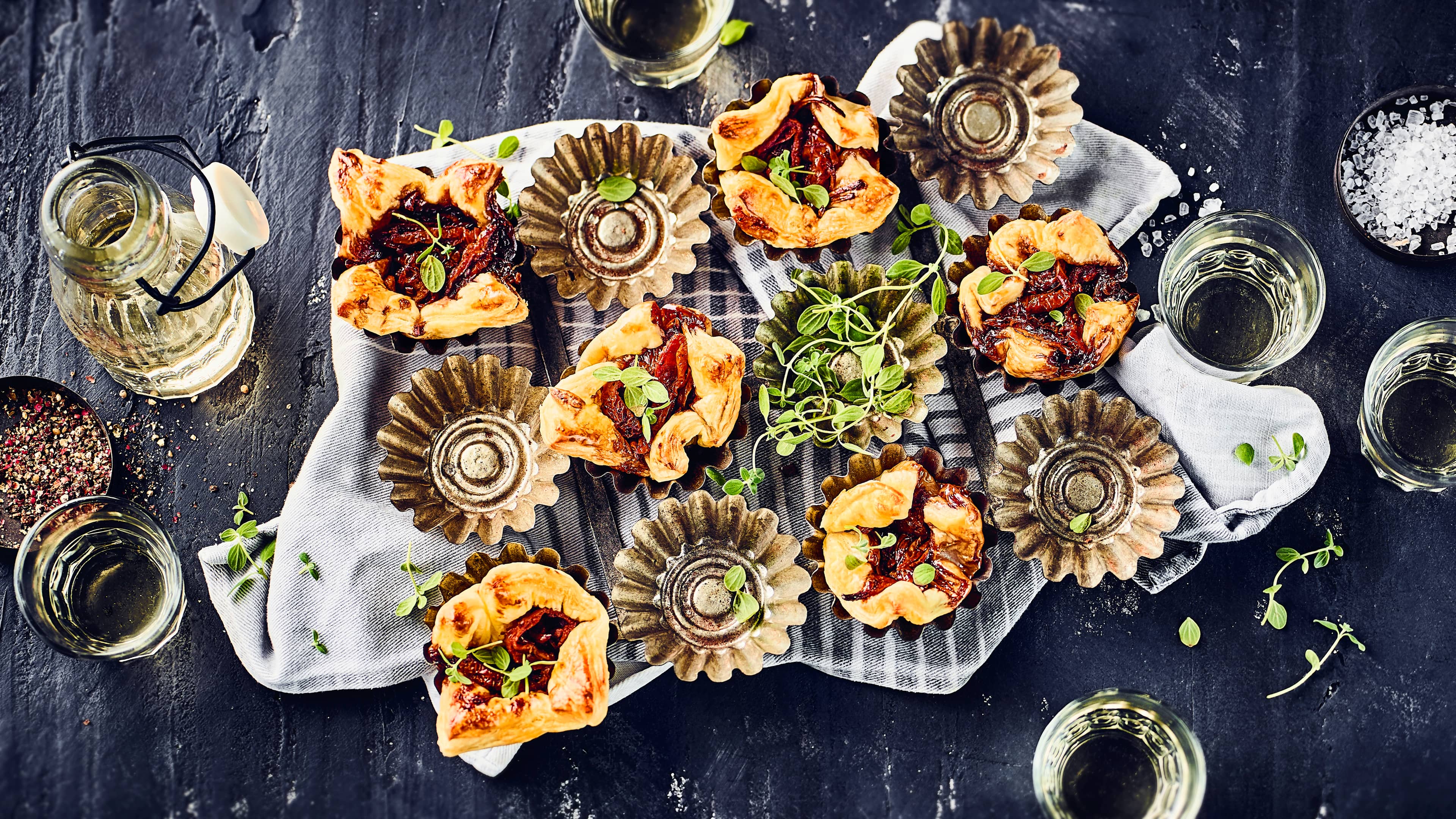 Blätterteigtörtchen Garantiert der Hingucker auf jeder Party- Probieren Sie unser Rezept für Blätterteigtörtchen mit Tomaten und Zwiebeln in Muffinförmchen gebacken.