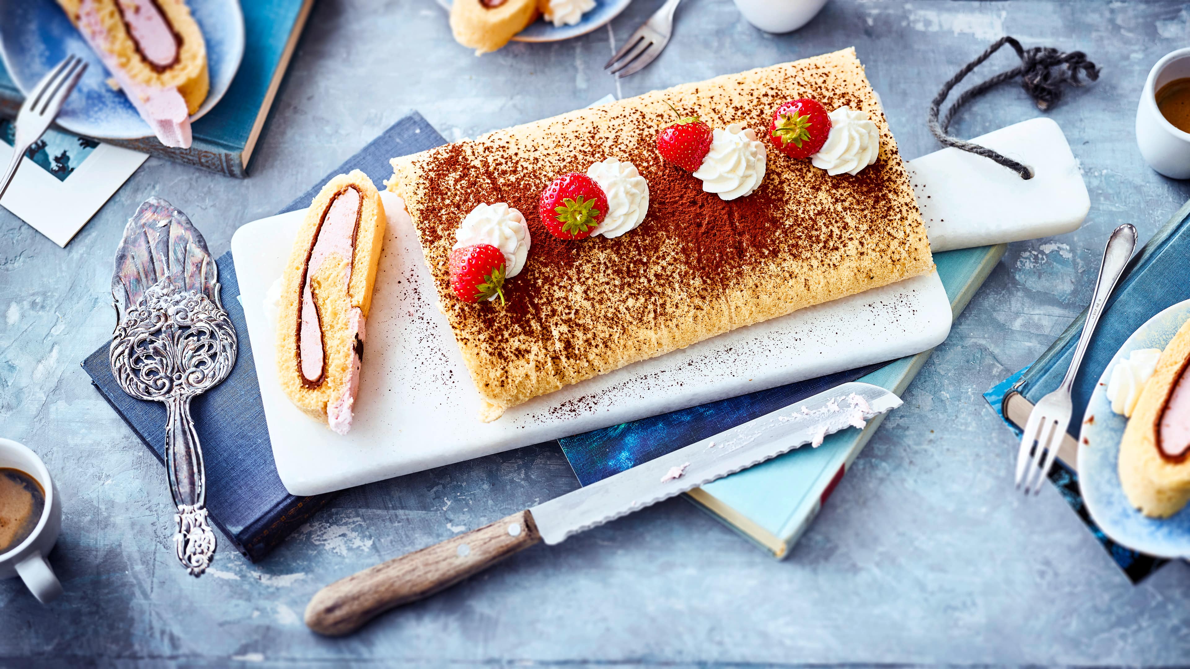 Erdbeer-Roulade Probieren Sie unser Rezept für eine Erdbeer-Biskuitroulade gefüllt mit einer fruchtigen Quarkcreme mit Sahne und Nuss-Nougat einmal aus – sommerlich frisch!