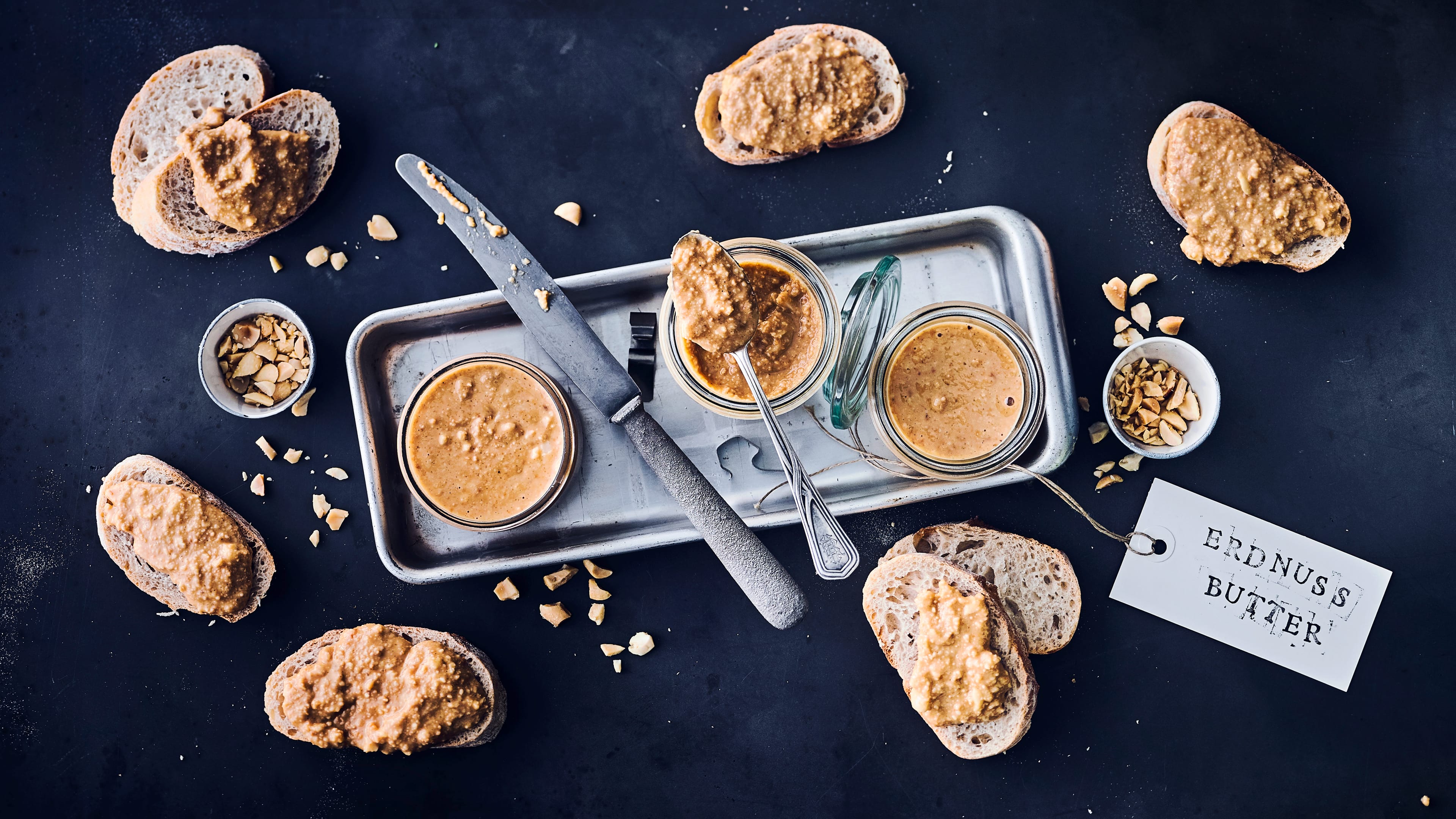 Erdnussbutter Selbst gemachte Erdnussbutter mit gerösteten Erdnüssen zum Frühstück auf einem knackigen Baguette – wer kann da schon wiederstehen?!
