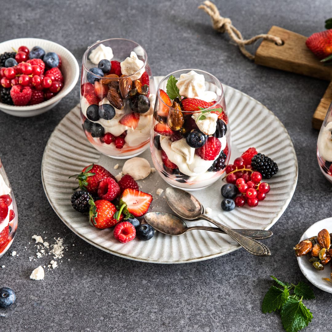 Beim nächsten Abendessen mit Freunden bringen Sie doch einfach das Dessert mit: Eton Mess – ein köstliches Dessert aus der englischen Küche aus Sahne, Baiser, frischen Beeren und Mandel-Krokant.