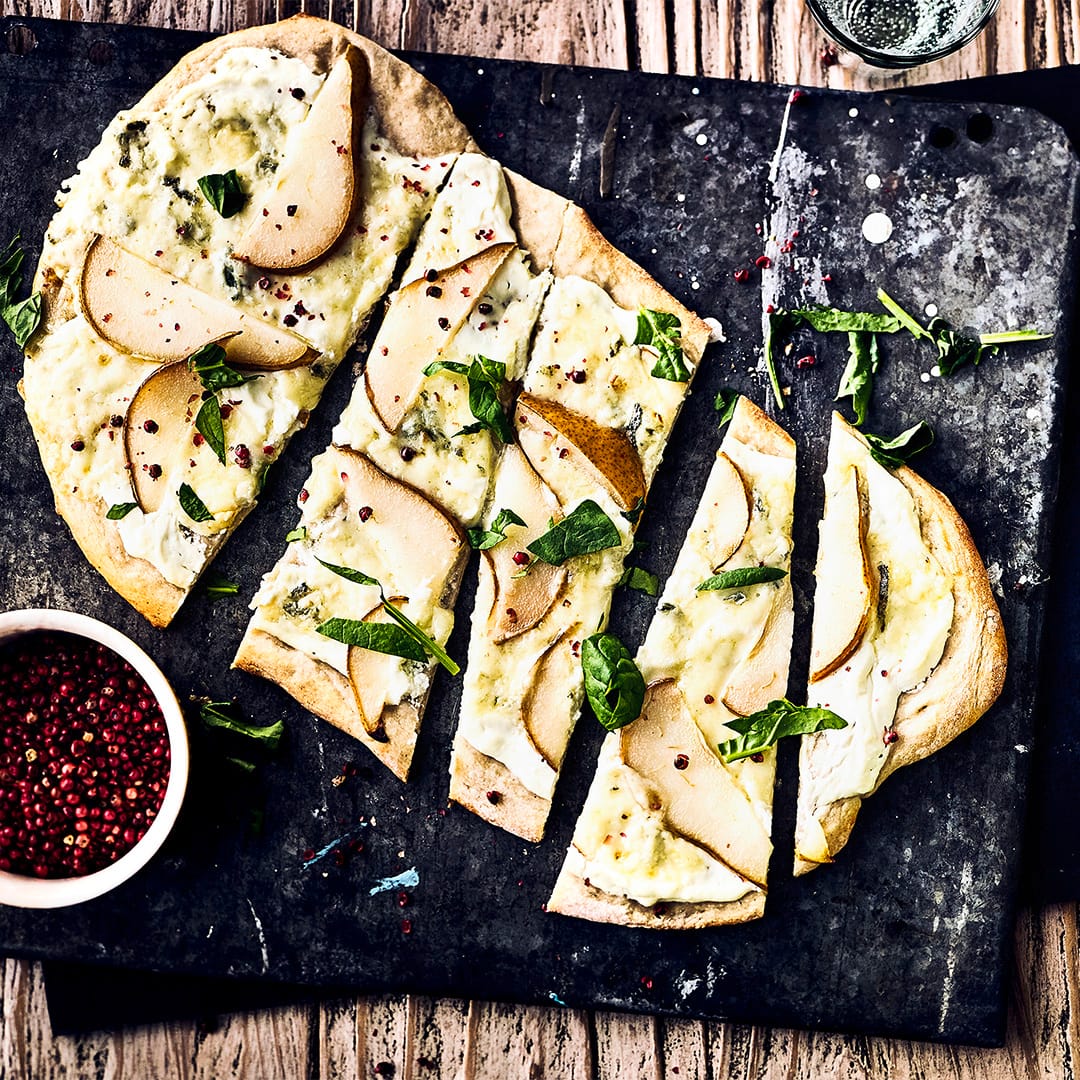 Backen Sie einen herzhaften Hefeteig und belegen Sie ihn mit frischen Birnen, Zitrone, Frischkäse oder Gorgonzola für einen leckeren Flammkuchen.