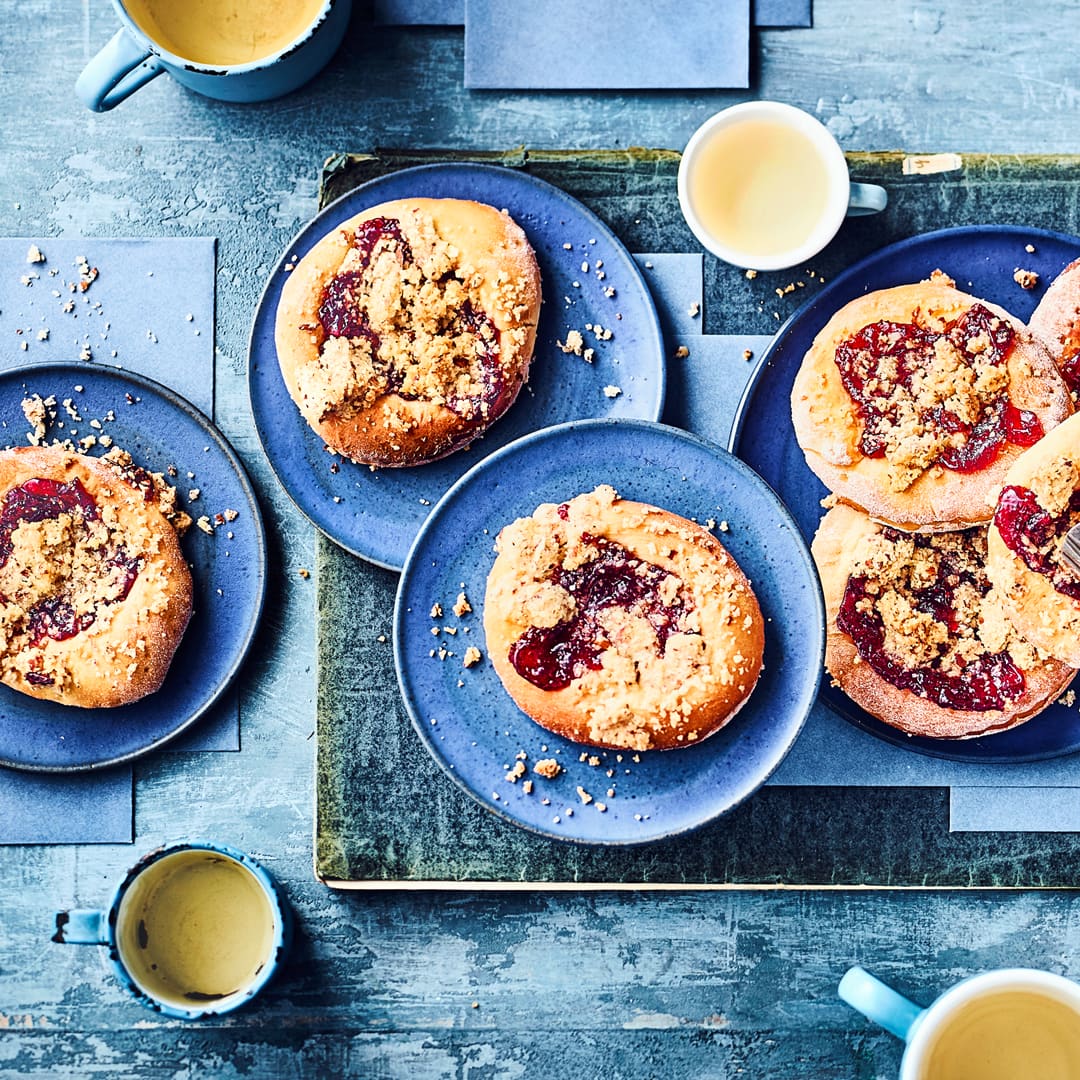 Mit unserem Hefegebäck-Rezept backen Sie köstliche Hefe-Teilchen mit Preiselbeermarmelade und Mandel-Butter-Streuseln.