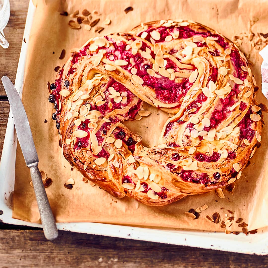 Ein Glanz auf der Kaffetafel: Köstlicher geflochtener Hefekranz mit einer fruchtigen Marzpian-Johannisbeerfüllung.