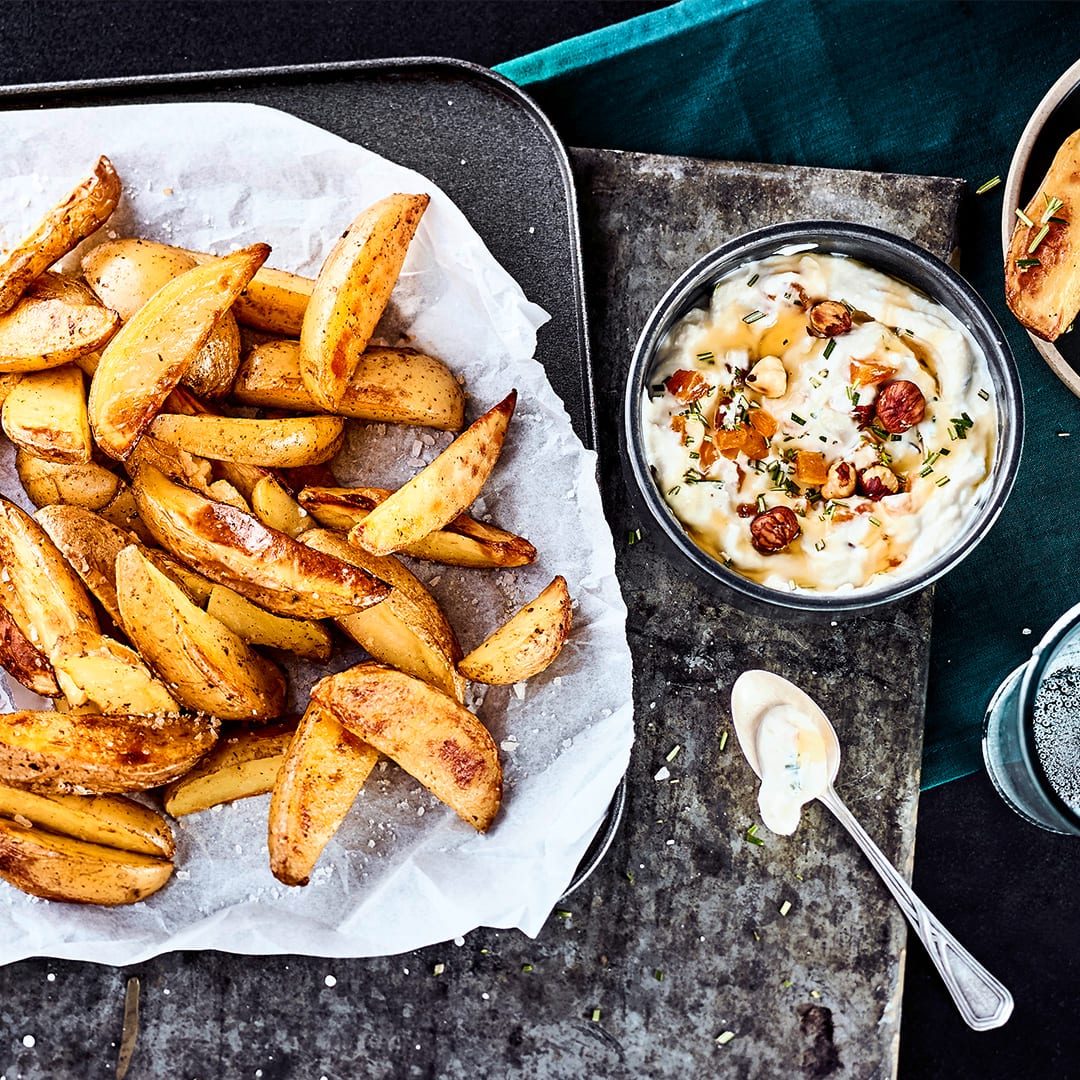 Ein perfekter Snack für Zwischendurch oder eine Beilage zur Hauptmahlzeit: Unser Rezept für selbstgemachte Kartoffelecken ergänzen wir um einen köstlichen Ziegenfrischkäse-Dip.