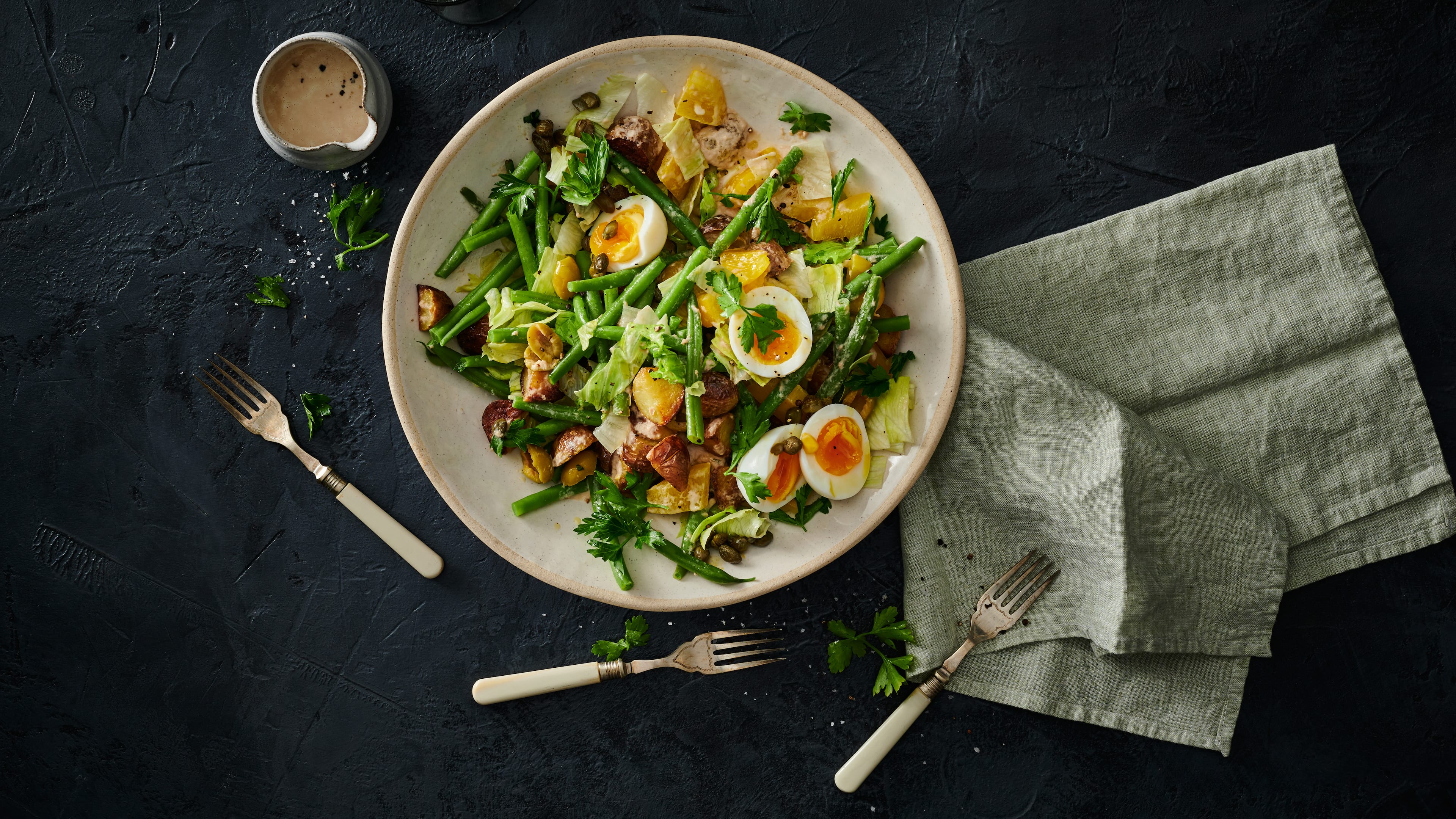 Kartoffelsalat geht immer! Wir servieren den Klassiker mit grünen Bohnen, Oliven, Thunfisch und gekochten Eiern.