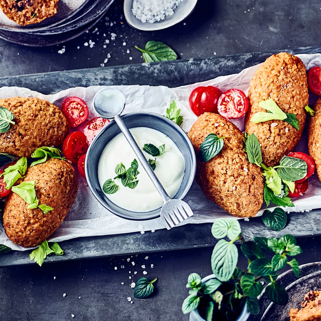 Kibbeh kommen aus dem Nahen Osten und sind und sind kleine selbst hergestellte Bällchen oder Klöße aus Bulgur und Hackfleisch. Dazu servieren wir einen selbstgemachten Joghurt-Minz-Dip!