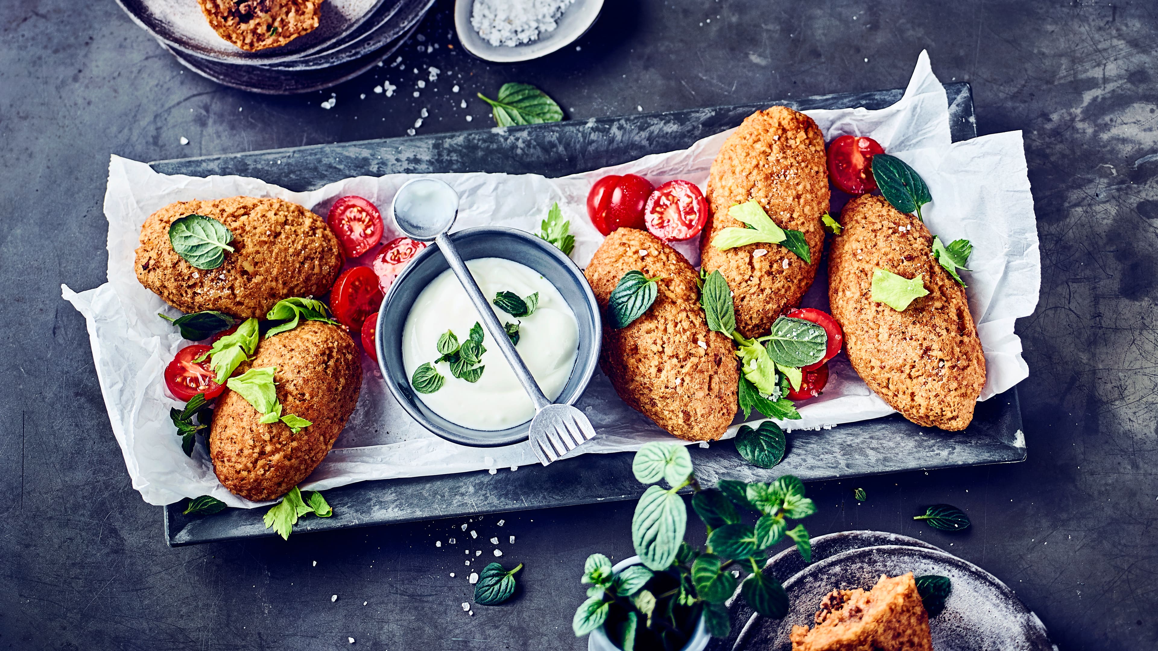 Kibbeh Kibbeh kommen aus dem Nahen Osten und sind und sind kleine selbst hergestellte Bällchen oder Klöße aus Bulgur und Hackfleisch. Dazu servieren wir einen selbstgemachten Joghurt-Minz-Dip!