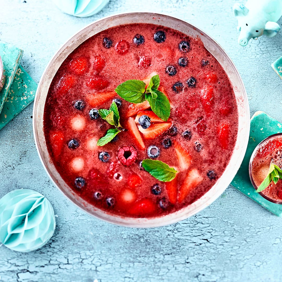 Ein Wow-Getränk für die nächste Geburtstagsparty: Selbstgemachte Kinderbowle mit viel frischen Beeren und Pfirsich – super fruchtig!