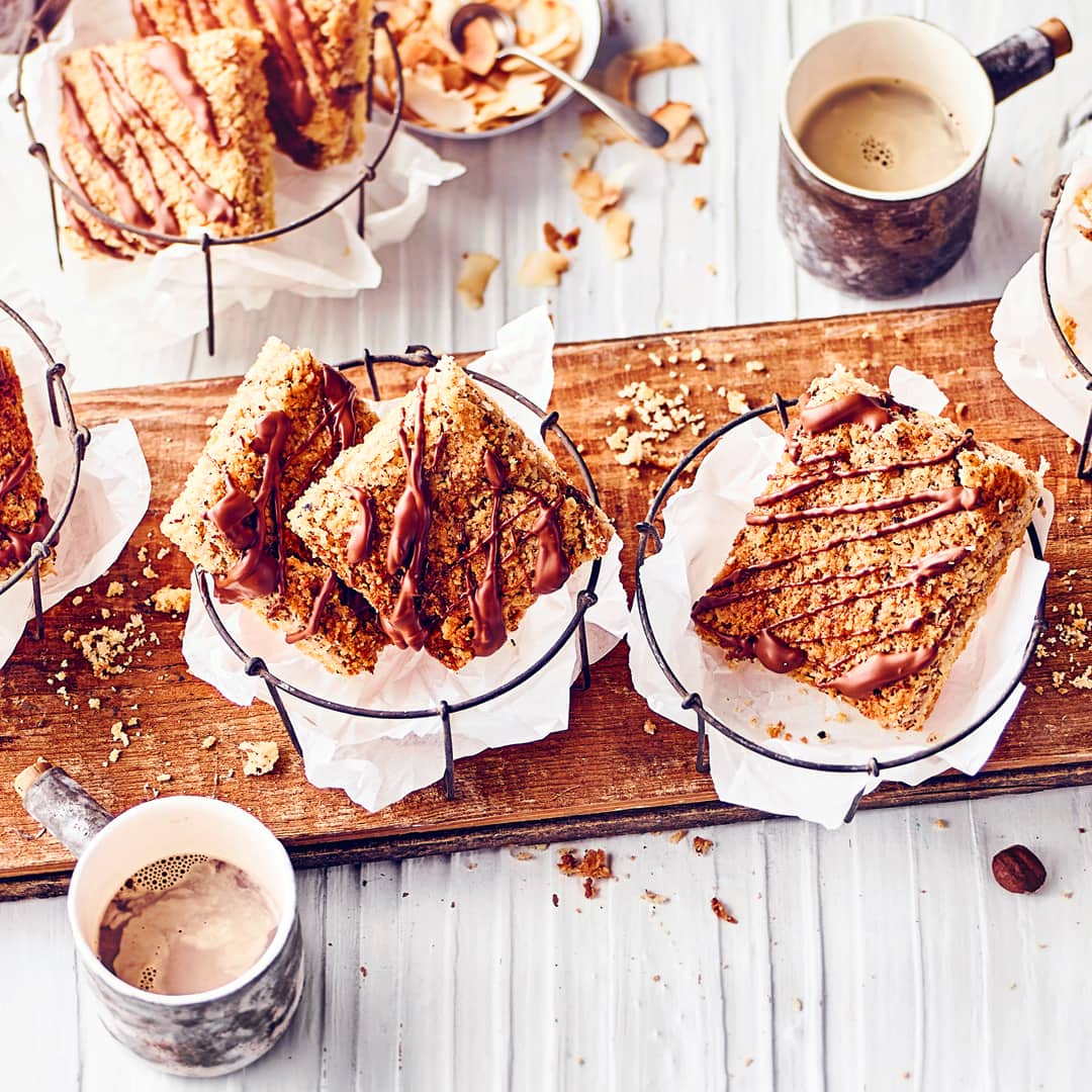 Cremige Nuss-Kokosmasse auf leckerem Mürbeteig gebacken, geschnitten und mit flüssiger Schokolade verziert.