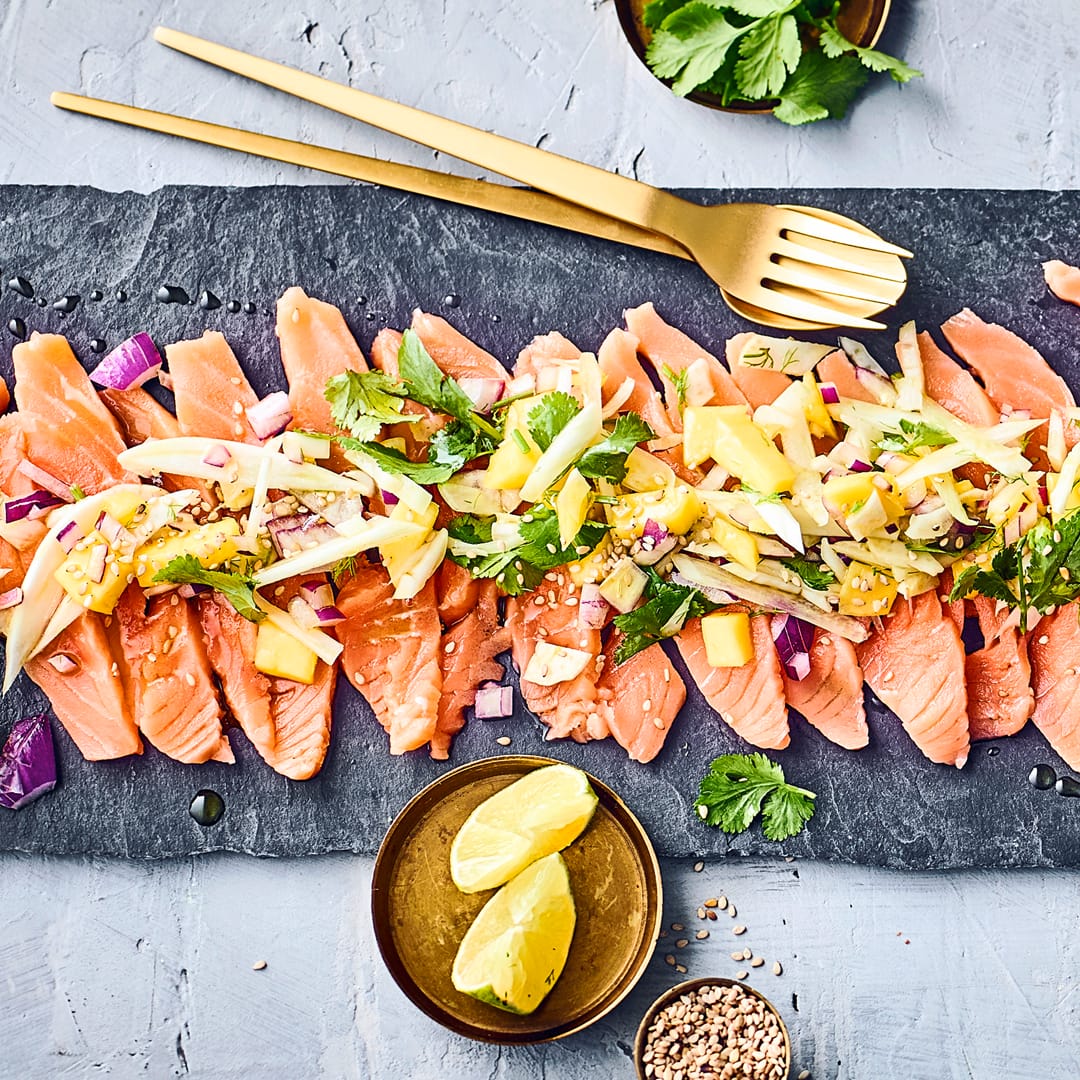 Ob als Vorspeise oder zum Buffet: Köstliches Lachs-Carpaccio mit einer selbstgemachten Fenchel-Mango-Marinade mit Sesamöl und Koriander.