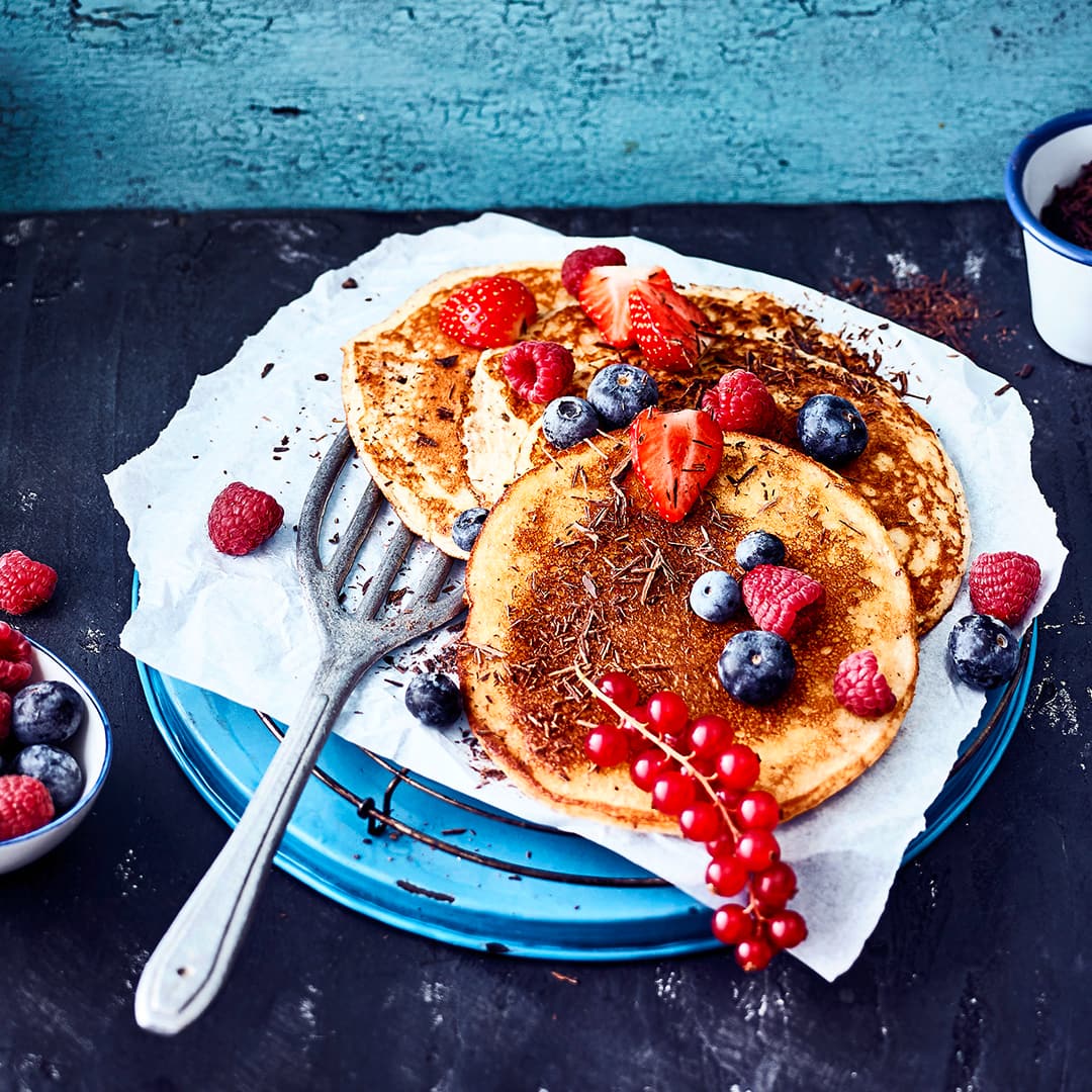 Low Carb und Pancakes – passt das zusammen? Aber natürlich! Unser Rezept für Pancakes braucht kein Mehl, sondern besteht aus Frischkäse, Speisequark, Eiern und gemahlenen Mandeln. Beeren und geraspelte Schokolade runden das Ganze ab.