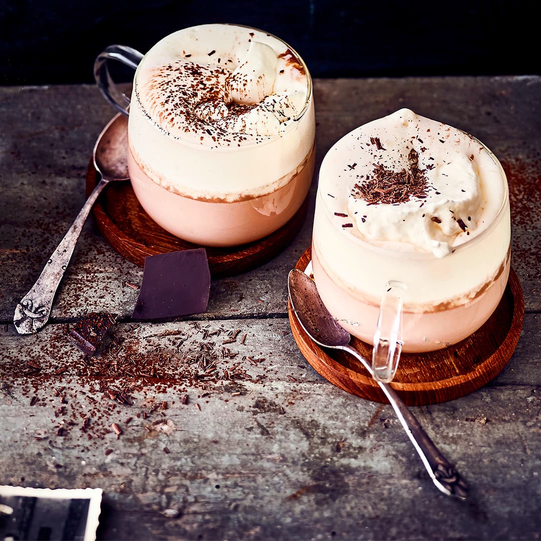 Weihnachtsmarkt Feeling pur: Leckere heiße Schokolade mit Rum und Amaretto und natürlich getoppt mit aufgeschlagener Sahne – unbedingt warm genießen.