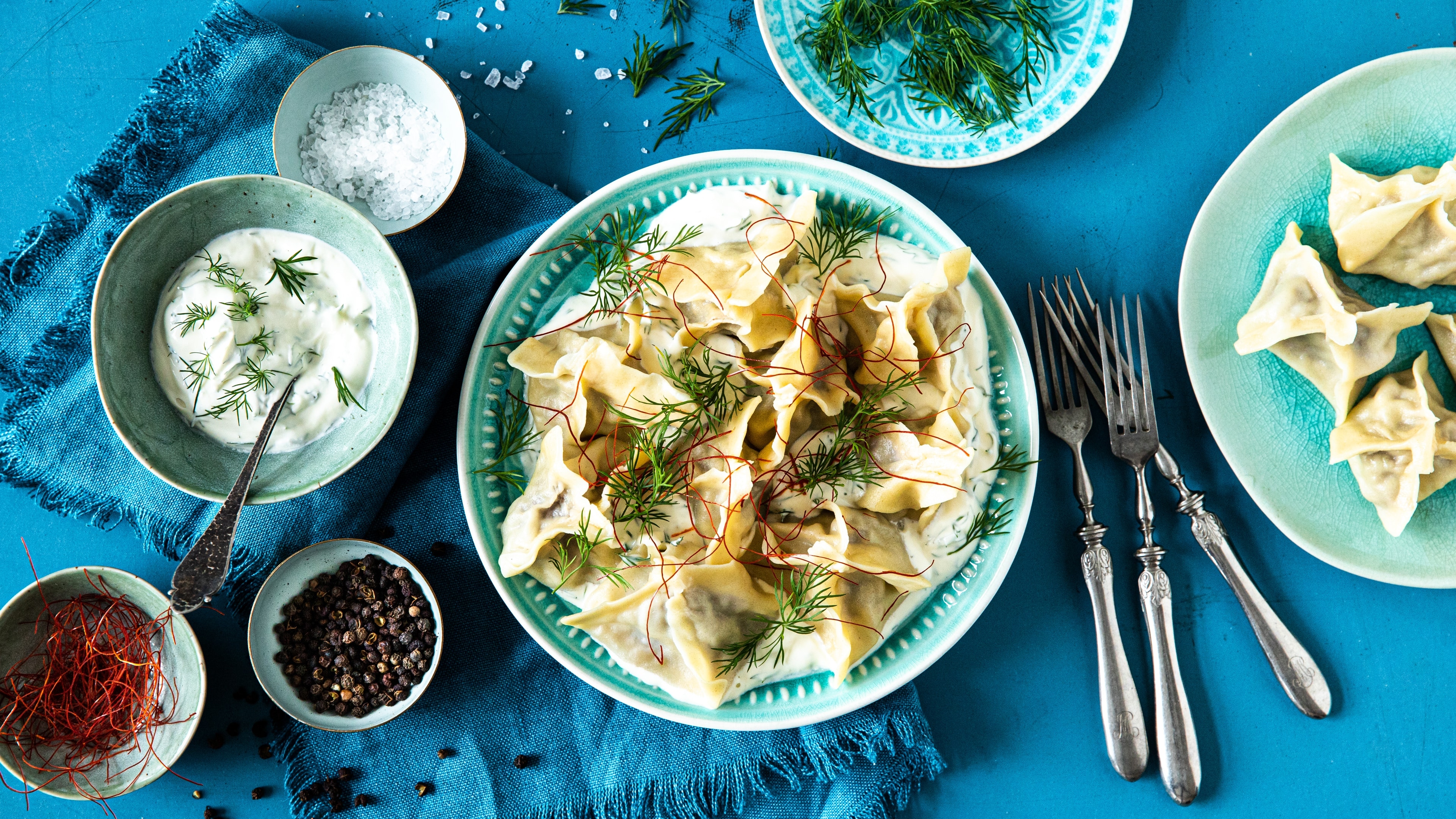 Manti Manti sind kleine mit Hackfleisch, Speck und Zwiebeln gefüllte Teigtaschen, die mit leckerer Soße aus Dill und Crème fraîche gereicht werden.