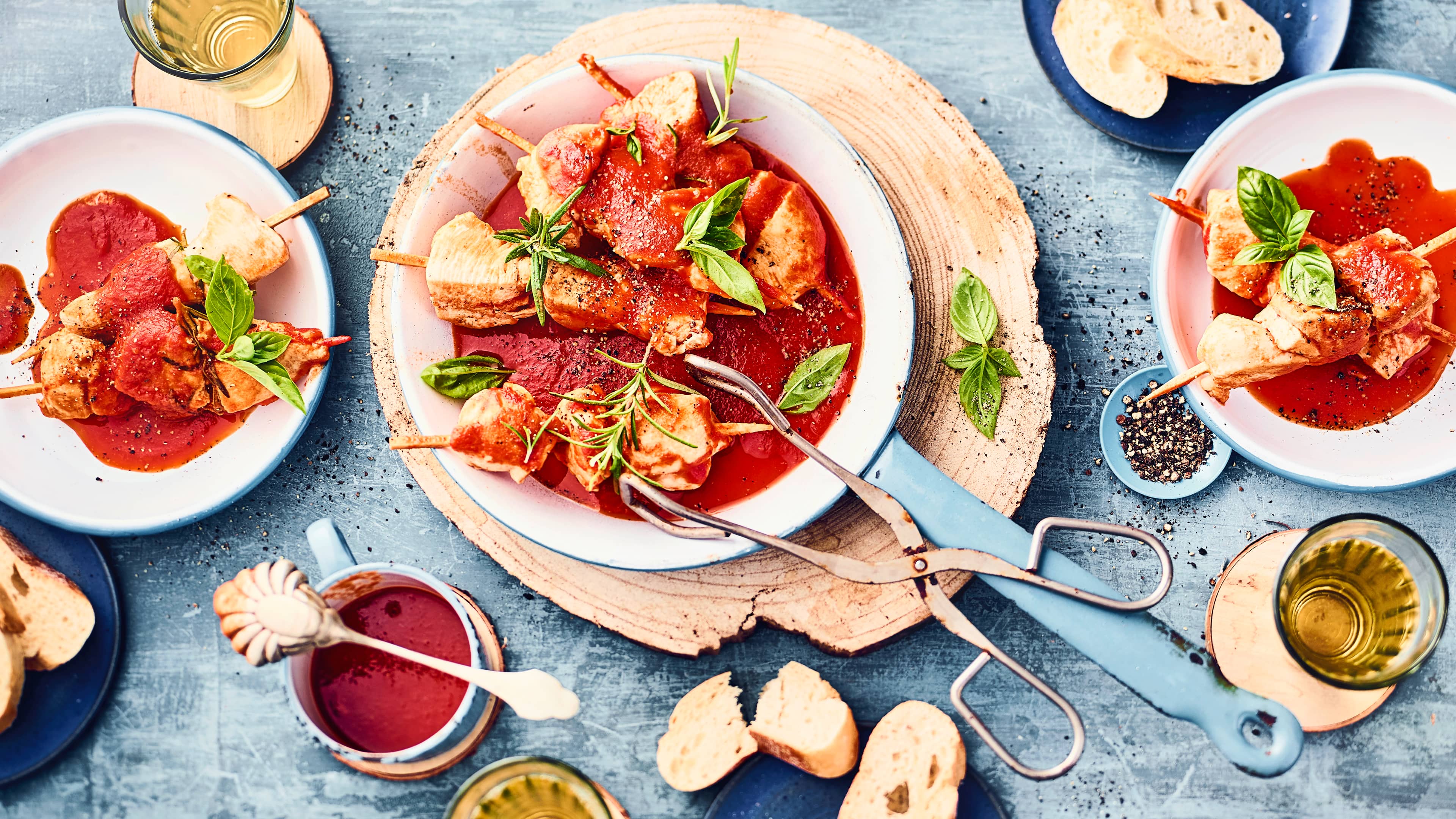 Marinierte Hähnchenspieße Genuss pur: unsere marinierten Hähnchenspieße mit saftigem Hähnchenbrustfilet in einer selbstgemachten Marinade für einen tollen Geschmack - dazu eine würzige Tomatensauce und frische Kräuter.
