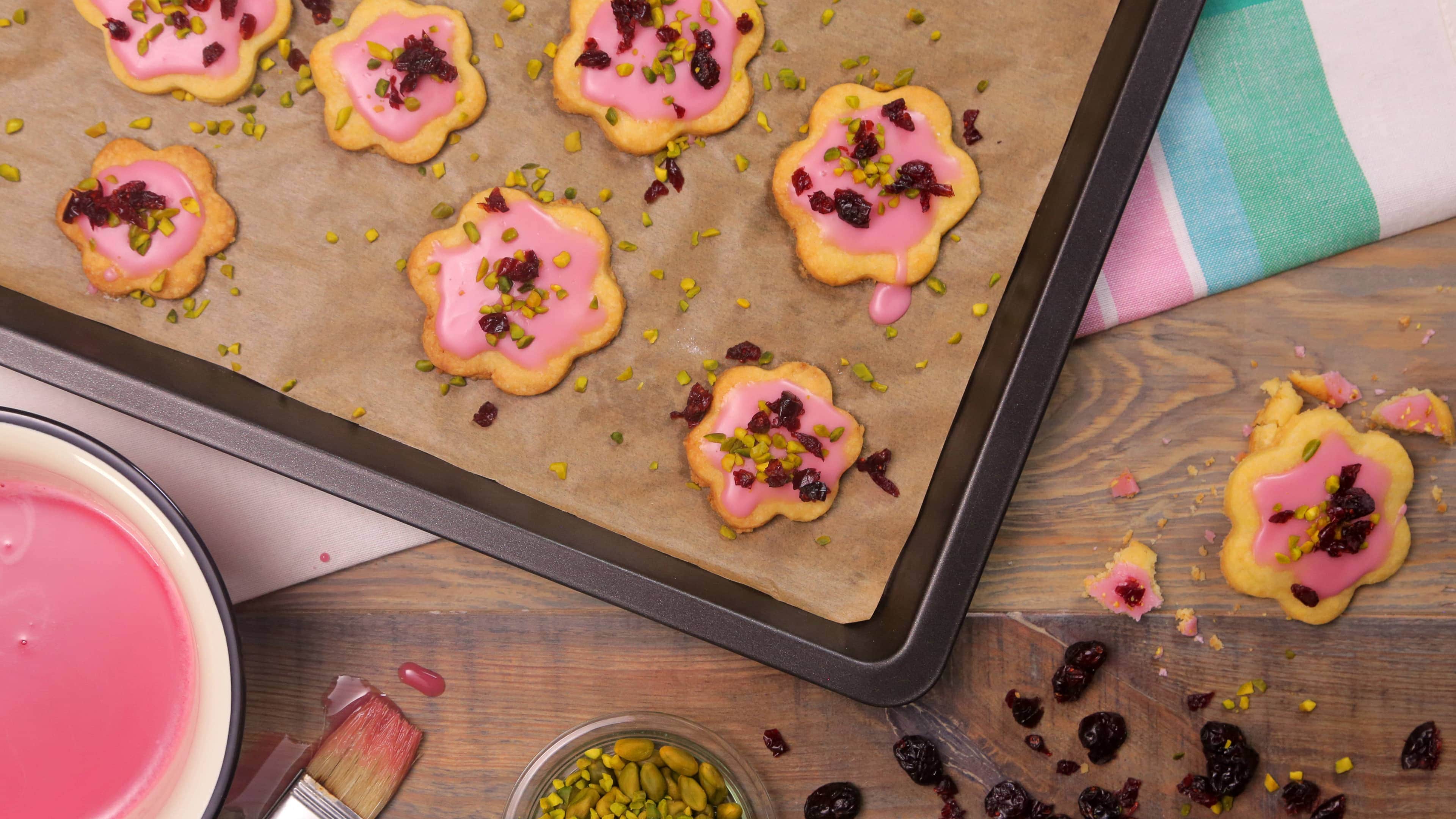 Mürbeteigkekse mit Cranberry Backen Sie unsere fruchtigen Kekse aus Mürbeteig! Getrocknete Cranberrys, Cranberrysaft und gehackte Pistazien geben den Plätzchen ihren süß-säuerlichen Geschmack – perfekt für Geburtstage und Partys.