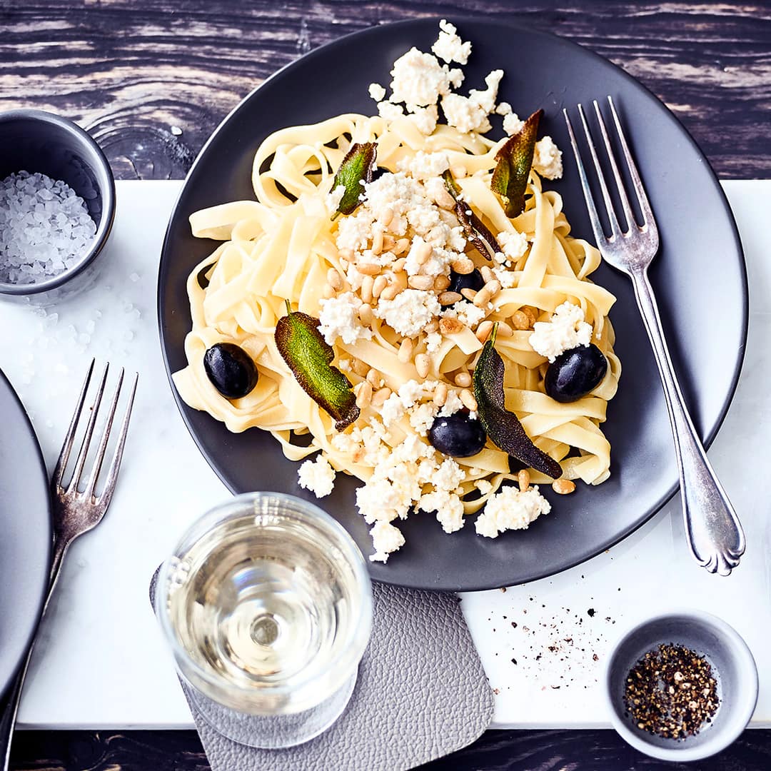 Schnelles Pastagericht vom Mittelmeer: Probieren Sie unsere Tagliatelle mit Oliven, Fetakäse und gerösteten Pinienkernen – fertig in 20 Minuten!