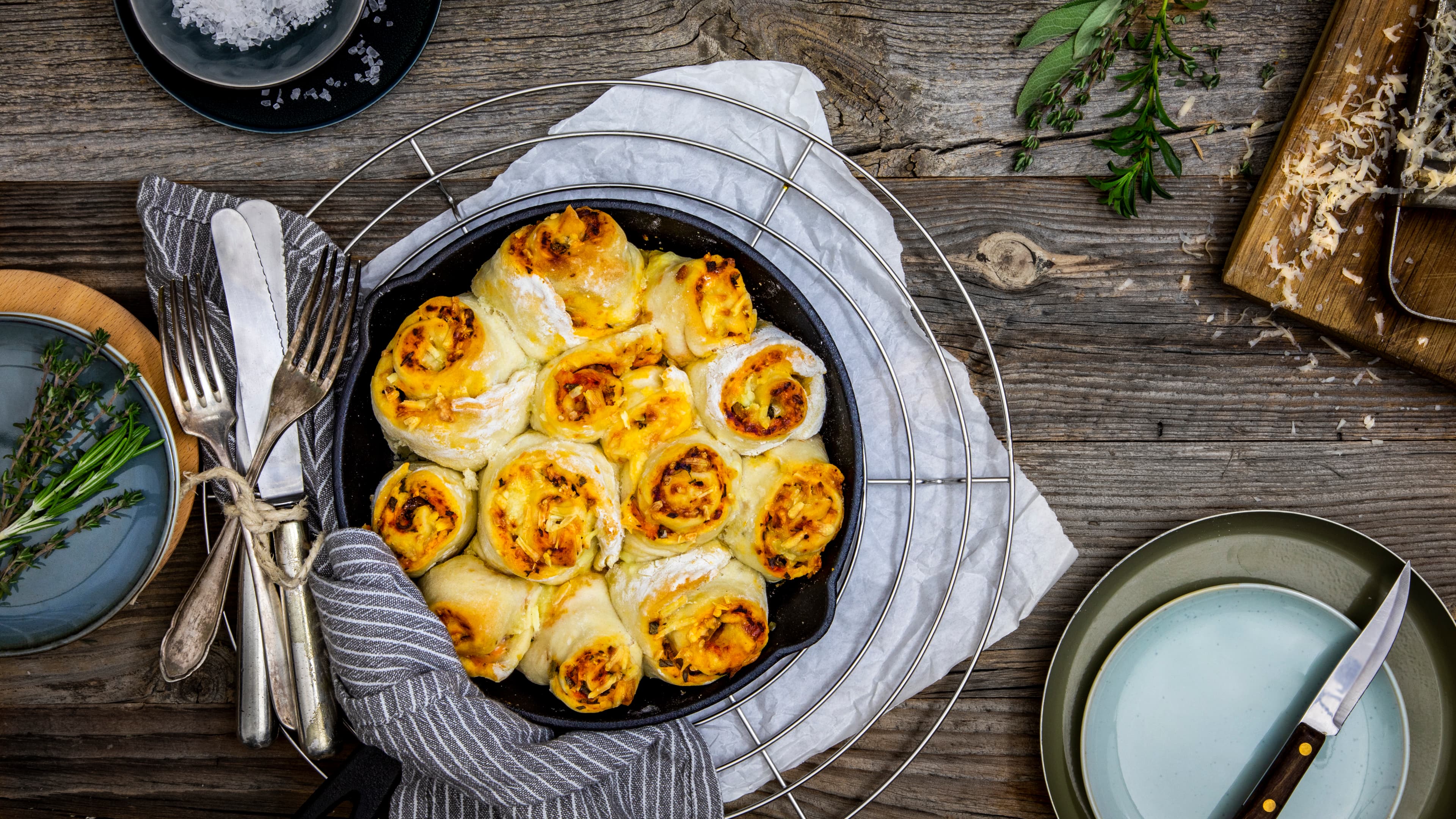 Rezept für Pizzabrötchen Gelbgold gebackene Teigschnecken, gefüllt mit Tomate und Gemüse, überbacken mit Käse, in einer gusseisernen Backform