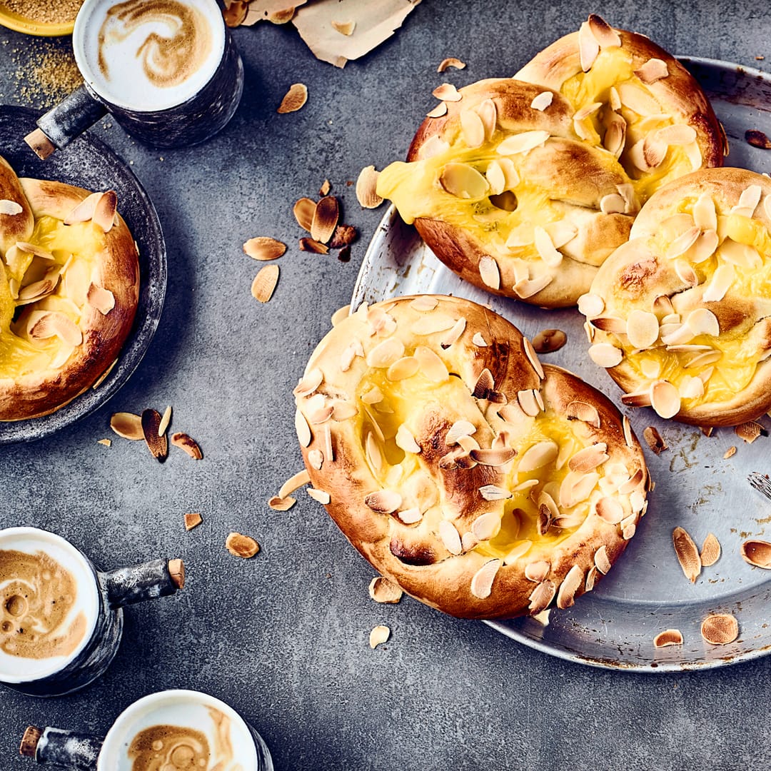 Unsere Puddingbrezeln sind cremig und knusprig zugleich. Natürlich können Sie diese fertig kaufen, aber dann entgeht Ihnen der unvergleichliche Duft wenn das gefüllte Hefegebäck im Ofen ist.
