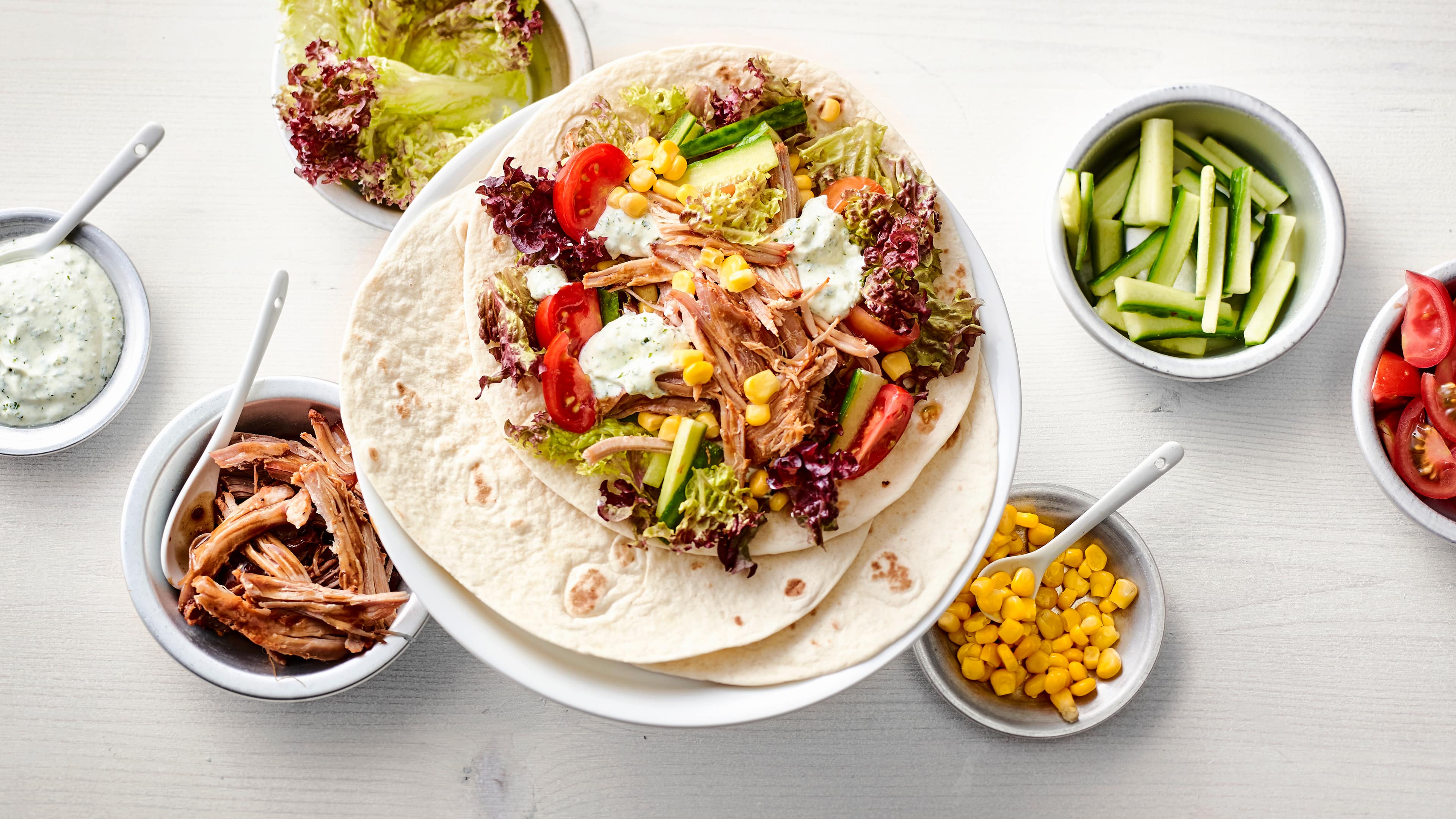 Rezept für Pulled Pork Wrap Wraps mit Pulled Fleisch, roter Blattsalat, Mais, Tomaten, Gurke und Kräutersoße, auf meinem Teller