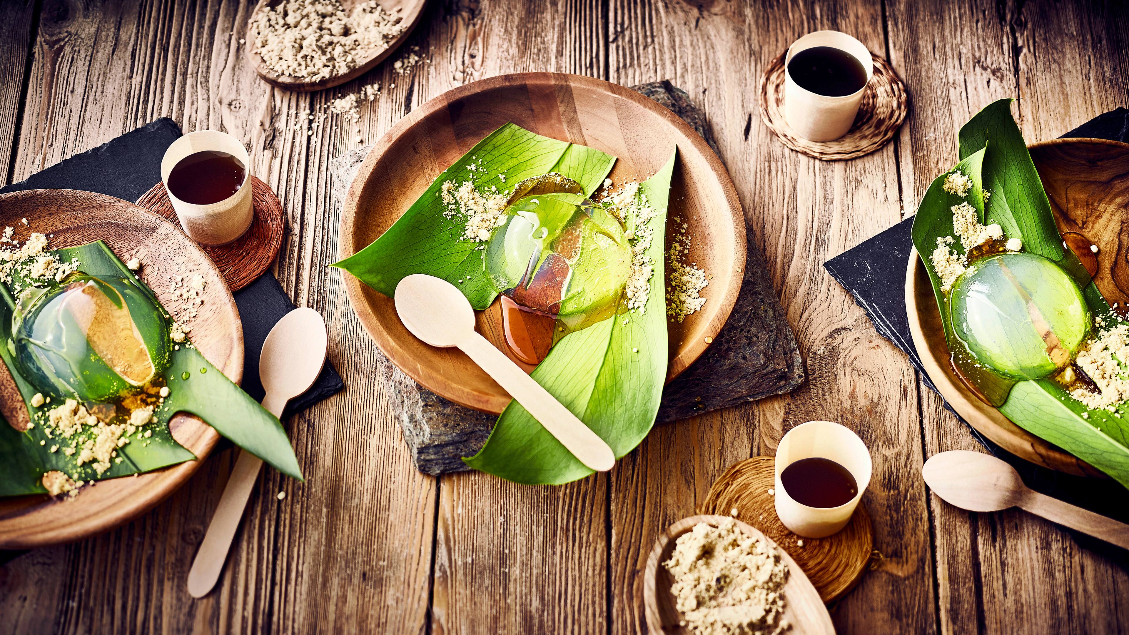 Raindrop Cake Den Namen haben die kleinen Küchlein durch Ihre Form und das Aussehen, das einem Regentropfen gleicht. Raindrop Cake wird mit Zuckersirup und Sojamehl garniert.