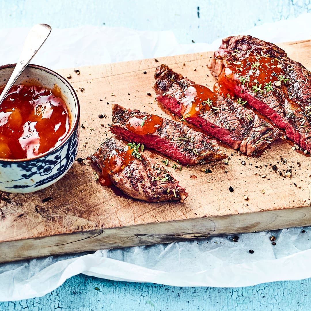 Probieren Sie unser Rezept für gegrillte Rindersteaks einmal aus: Mariniert in Öl, Rosmarin und Thymian und mit gebratenen Zwiebeln und Cocktailtomaten!