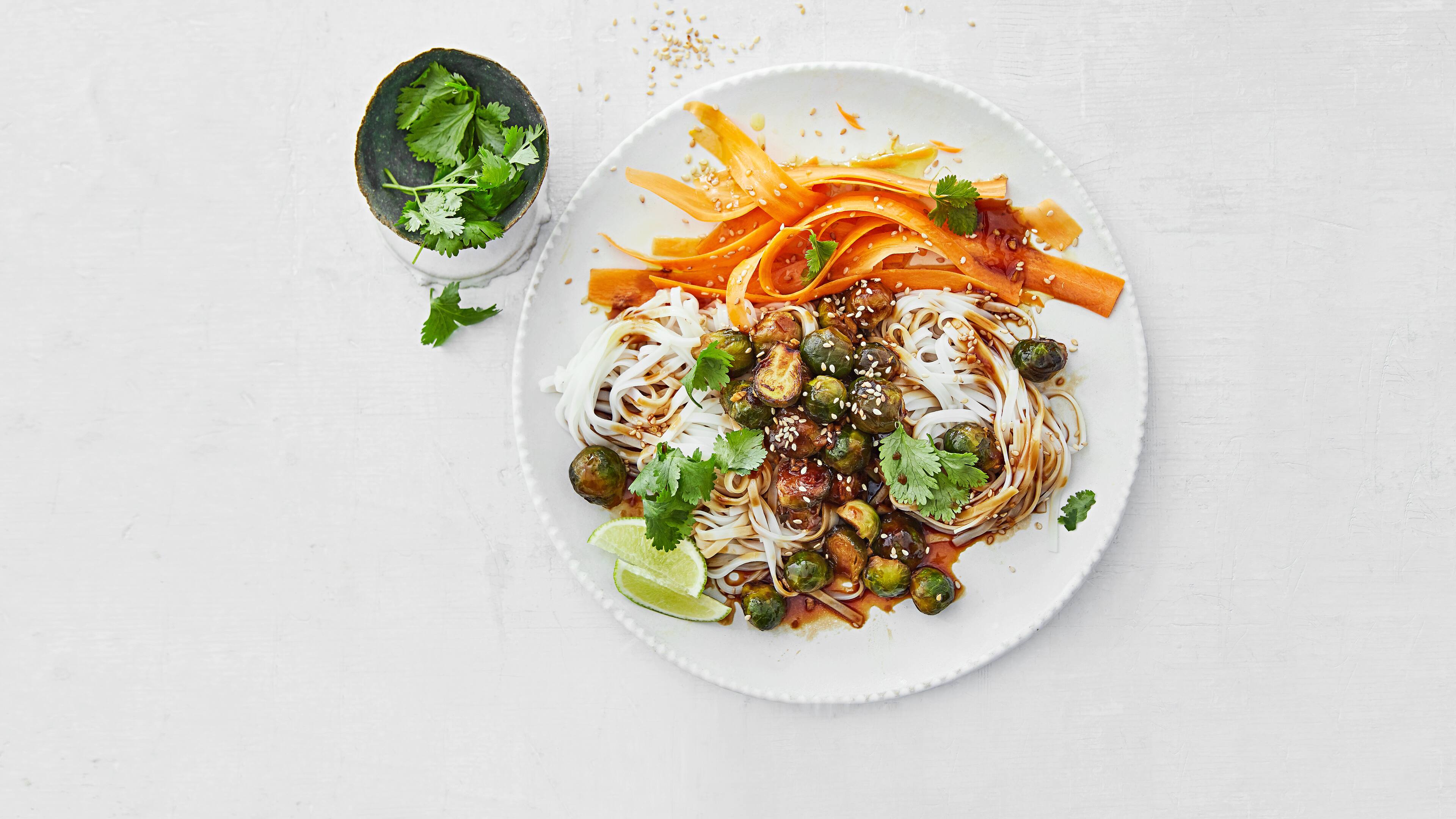 Rosenkohlpfanne mit Karotten & Reisbandnudeln Die kleinen Rosenkohlknospen sind wahre Wunderbälle und ergeben in Kombination mit Karotten und Reisbandnudeln eine leckere Mahlzeit, die nicht schwer im Magen liegt.