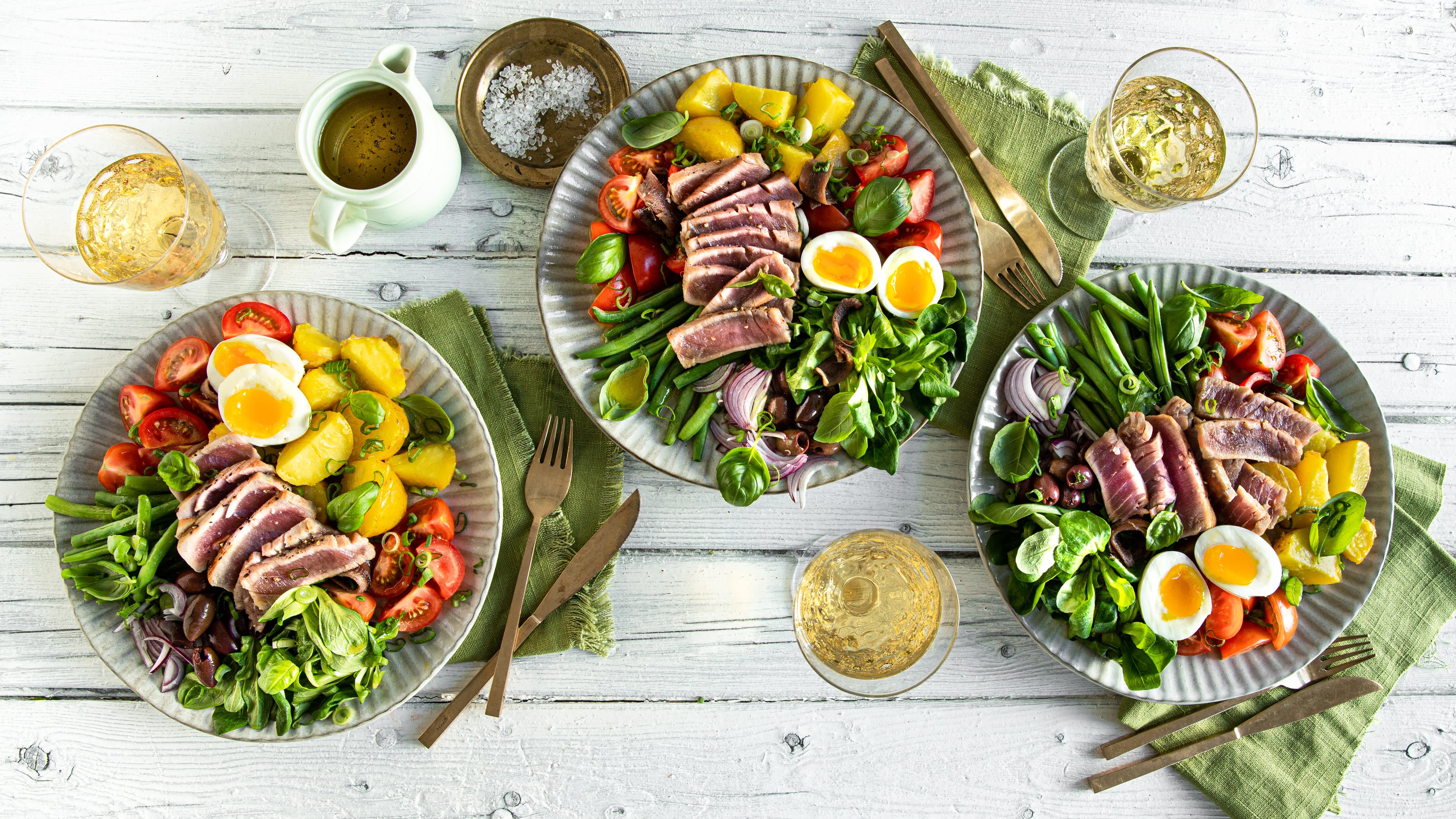 Salat à la Nizza Es gibt den Nizza-Salat in mehreren Varianten, wir servieren den Klassikern mit Kartoffelsalat, Eiern, Bohnen, Tomaten, Sardellen und frischem Thunfischfilet.