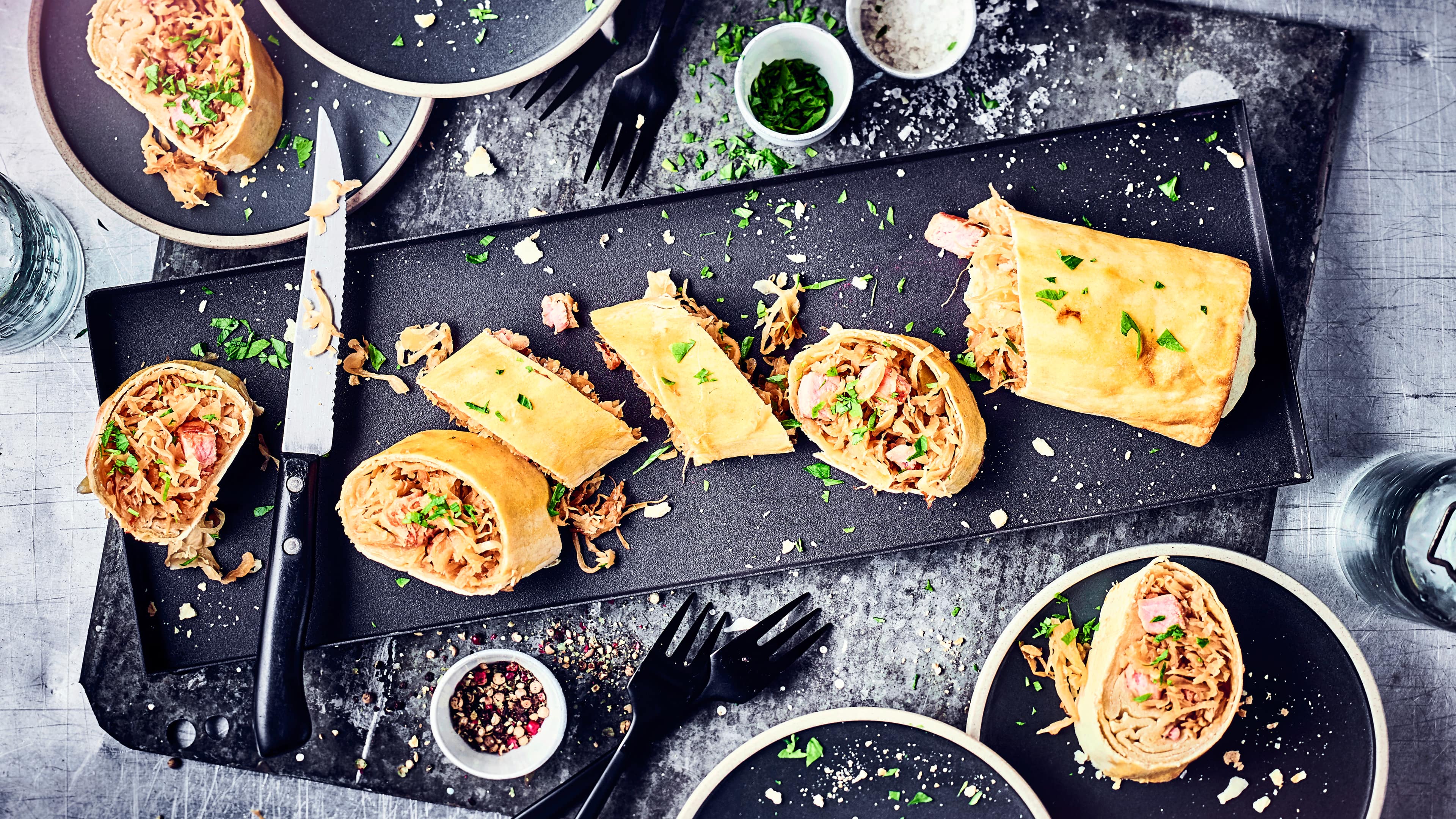 Unser Tipp für ein deftiges Wintergericht: Probieren Sie unseren selbst gemachten, herzhaften Strudel gefüllt mit Sauerkraut, saftigem Kassler und Möhren!
