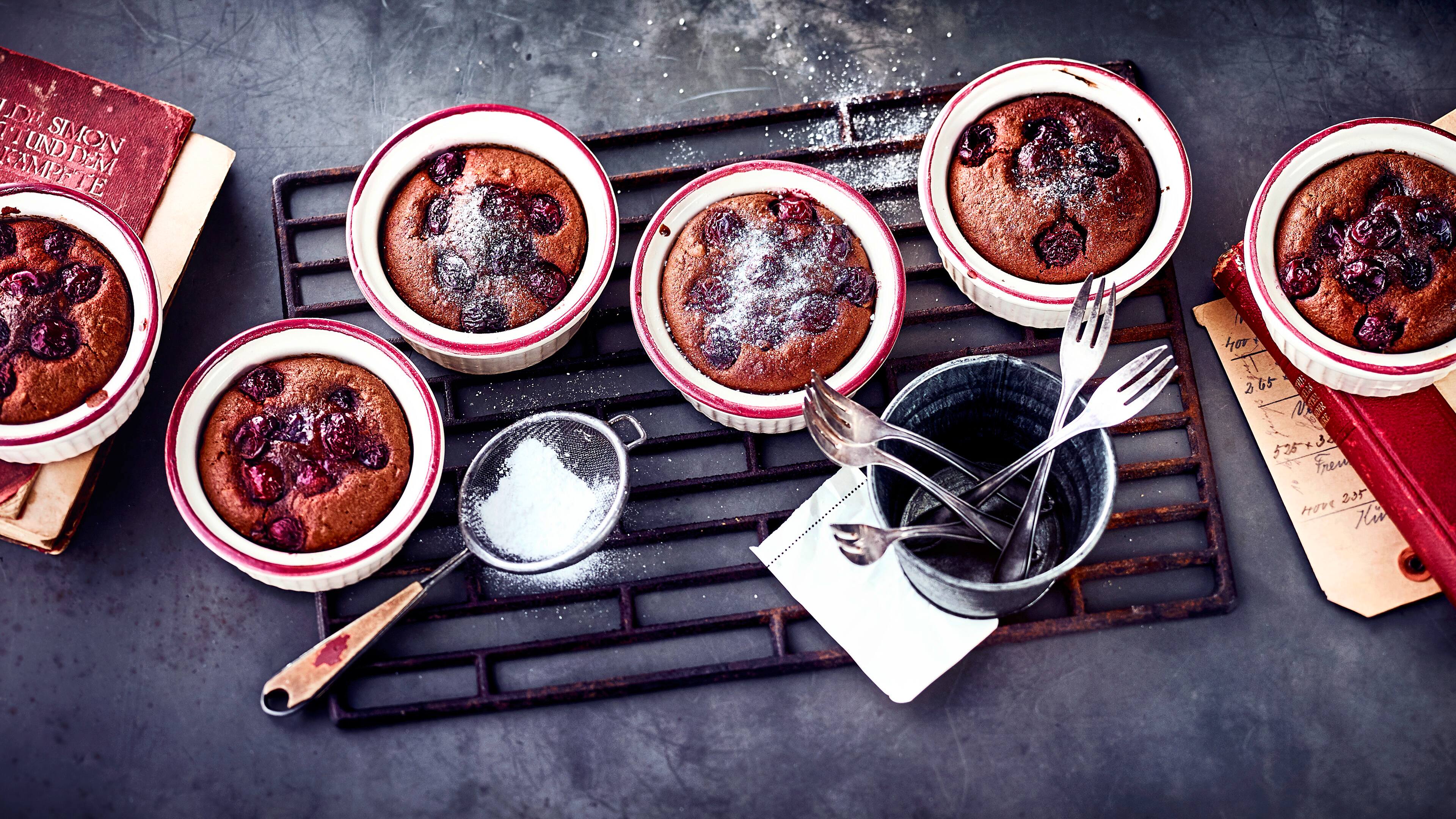 Rezept für Schokokirschkuchen vom Grill Keramikgläschen mit fluffigen Schokoküchlein mit Kirschen, bestreut mit feinem Puderzucker