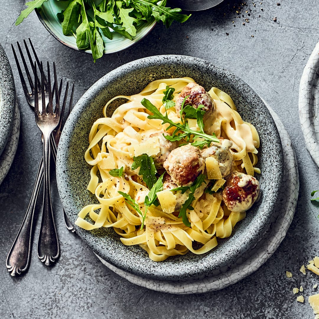 Bällchen aus Geflügelhackfleisch mit Sahnesauce und Tagliatelle.