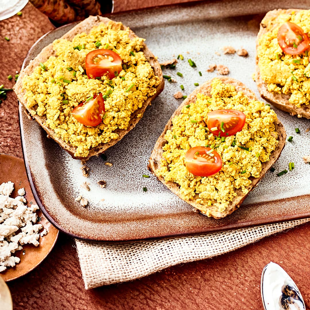 Sie möchten sich ein rein veganes Tofu-Frühstück zubereiten? Dann testen Sie unser Tofu-Rührei-Rezept mit Kurkuma, Tomaten und Mandelmus!