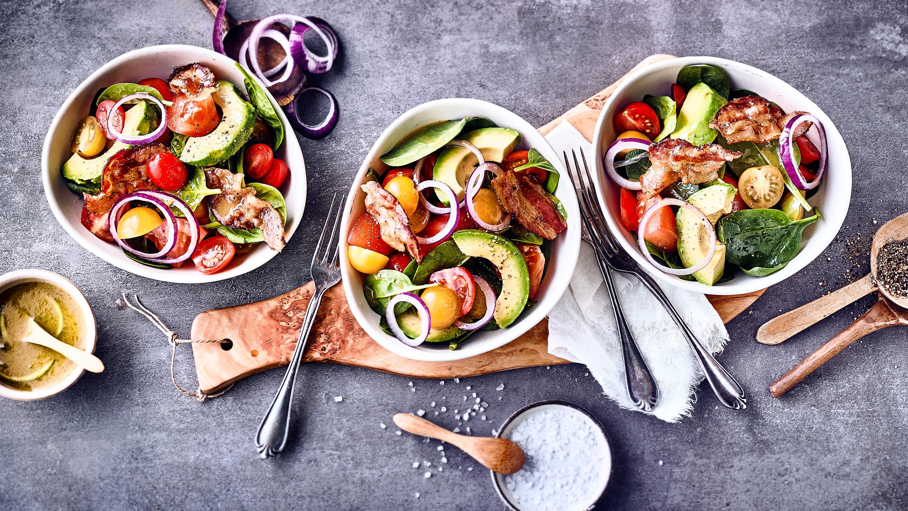 Tomaten-Avocado-Salat Allerlei leckere Zutaten und ein selbstgemachtes Apfel-Dressing ergeben unseren Tomaten-Avocado-Salat mit Tomaten, Avocado, gebratenem Speck und Babyspinat.
